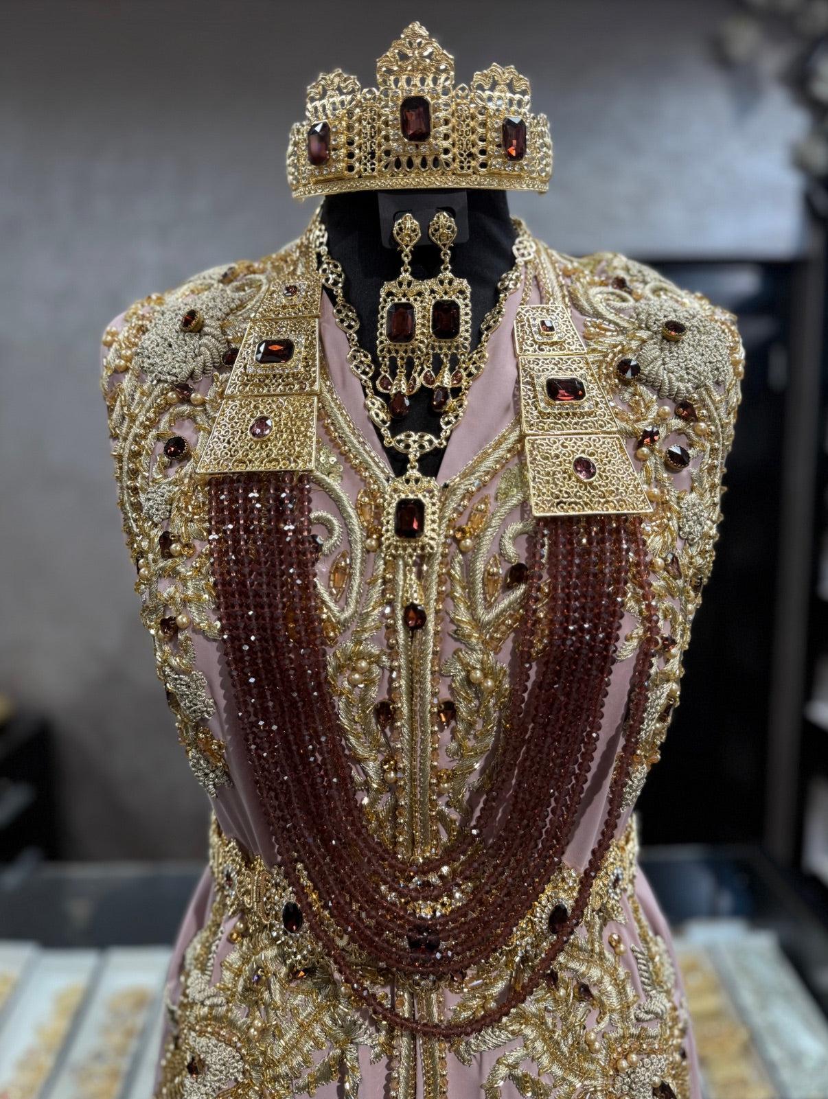 Marokkaanse bruidssieraden goud met bordeauxstenen, inclusief kroon, hoofdketting, oorbellen, ketting en lange ketting met kralen.