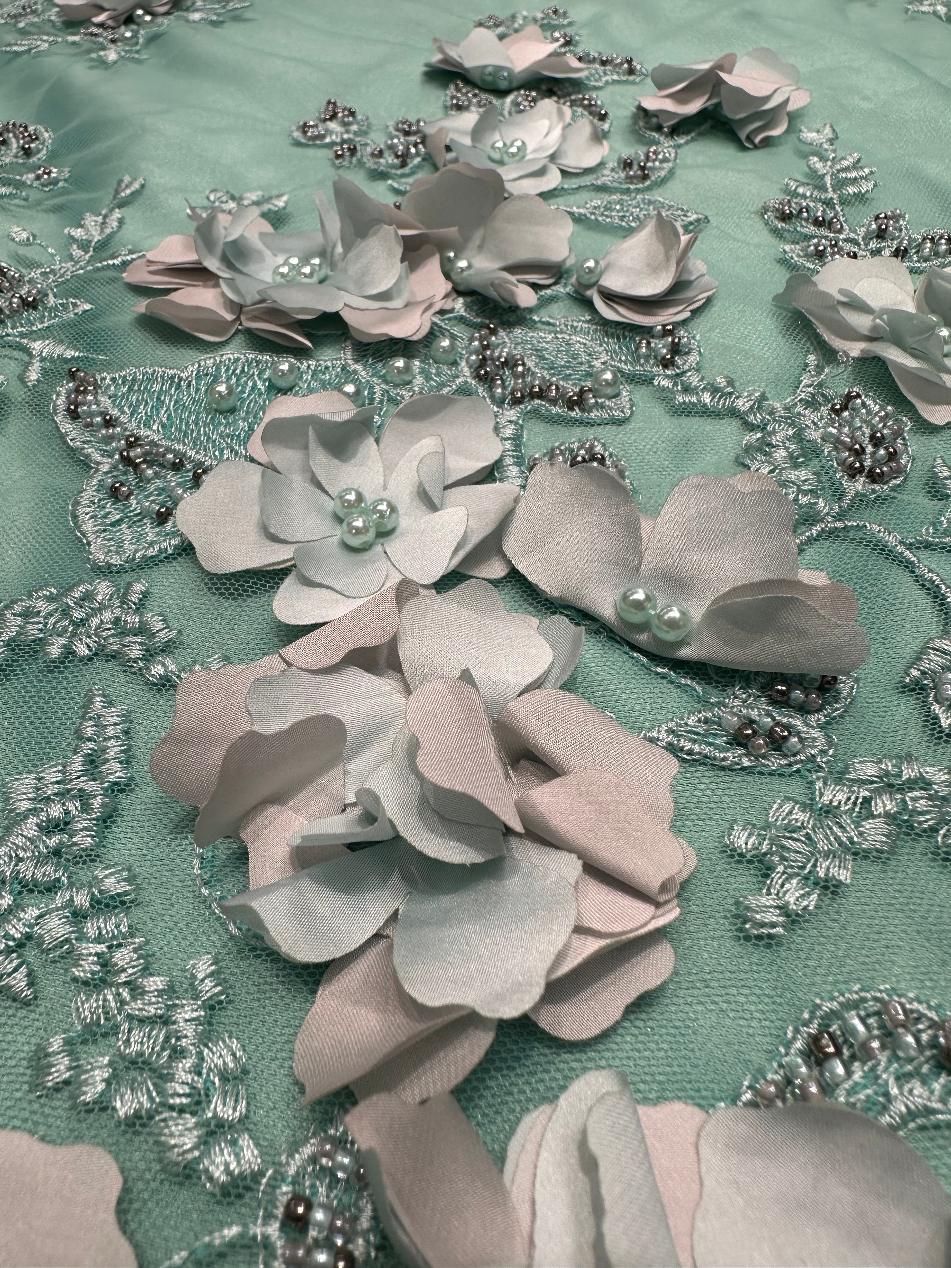 Detailfoto van groene kant stof met 3D bloemen, zichtbaar patroon en textuur, ideaal voor avondjurk en traditionele kleding