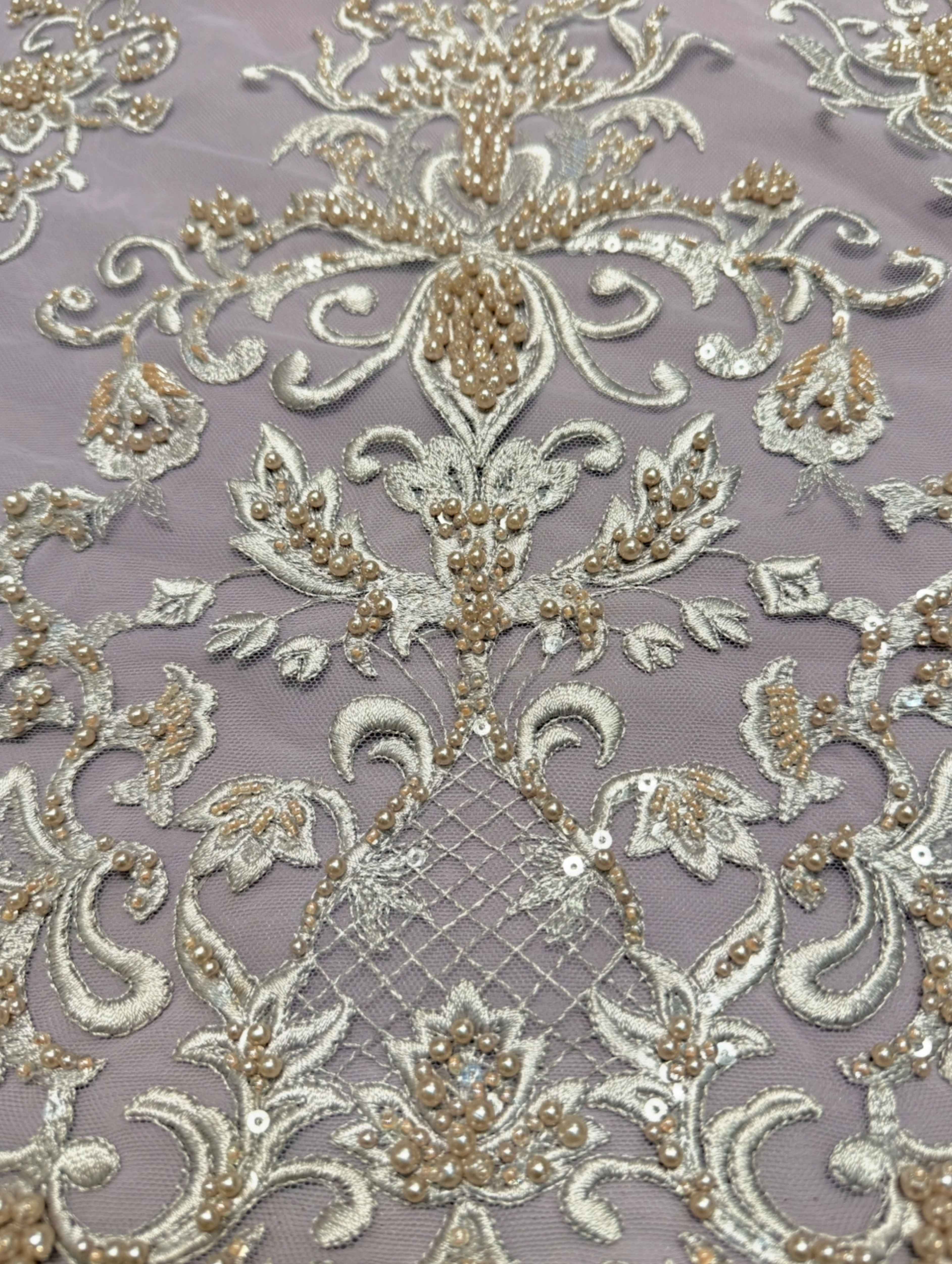 Detailfoto van lila kant stof met verfijnde parels, zichtbaar patroon en textuur, ideaal voor avondjurk en traditionele kleding