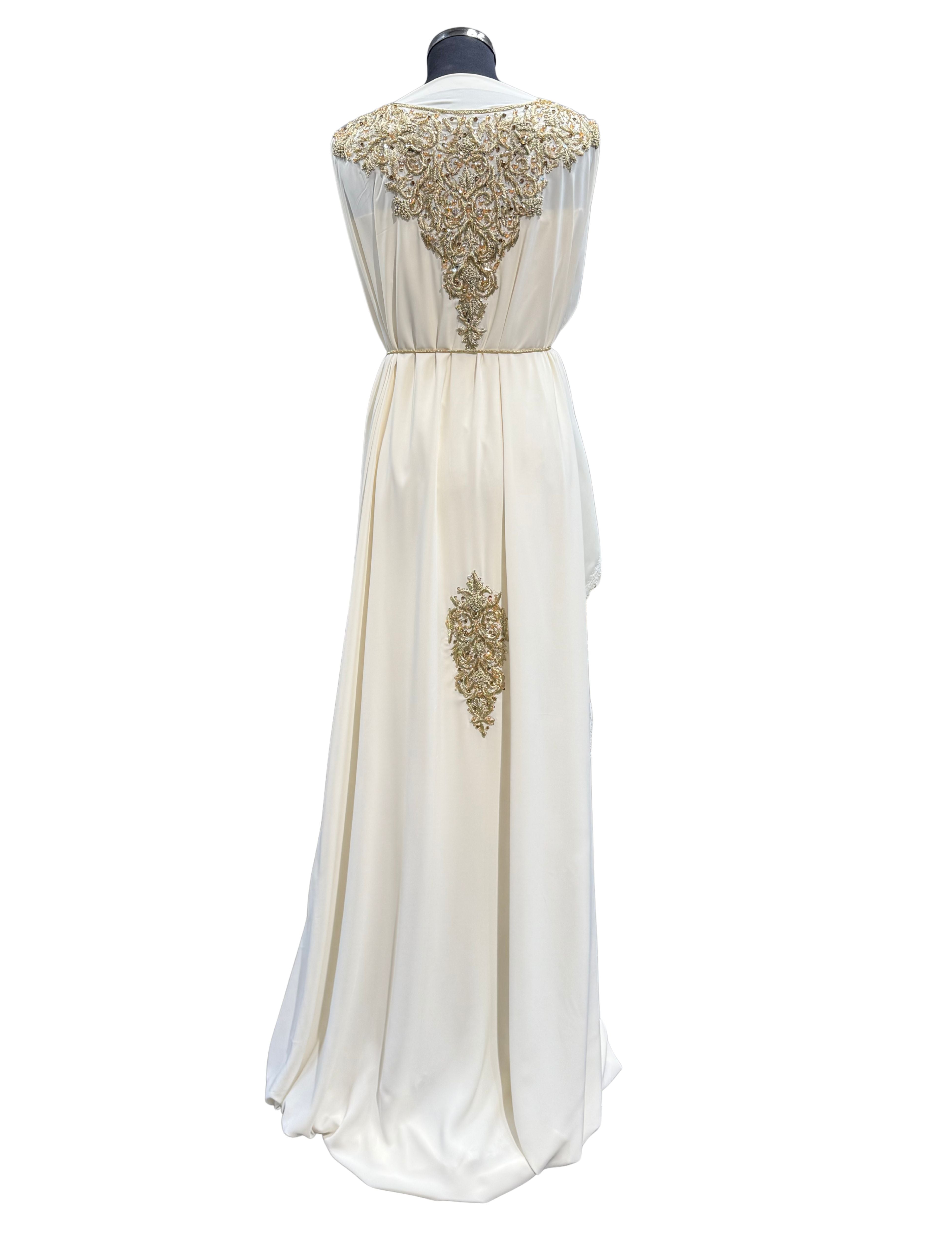 Achterkant van crème soepel vallende crêpe stof met goudkleurig borduurwerk.