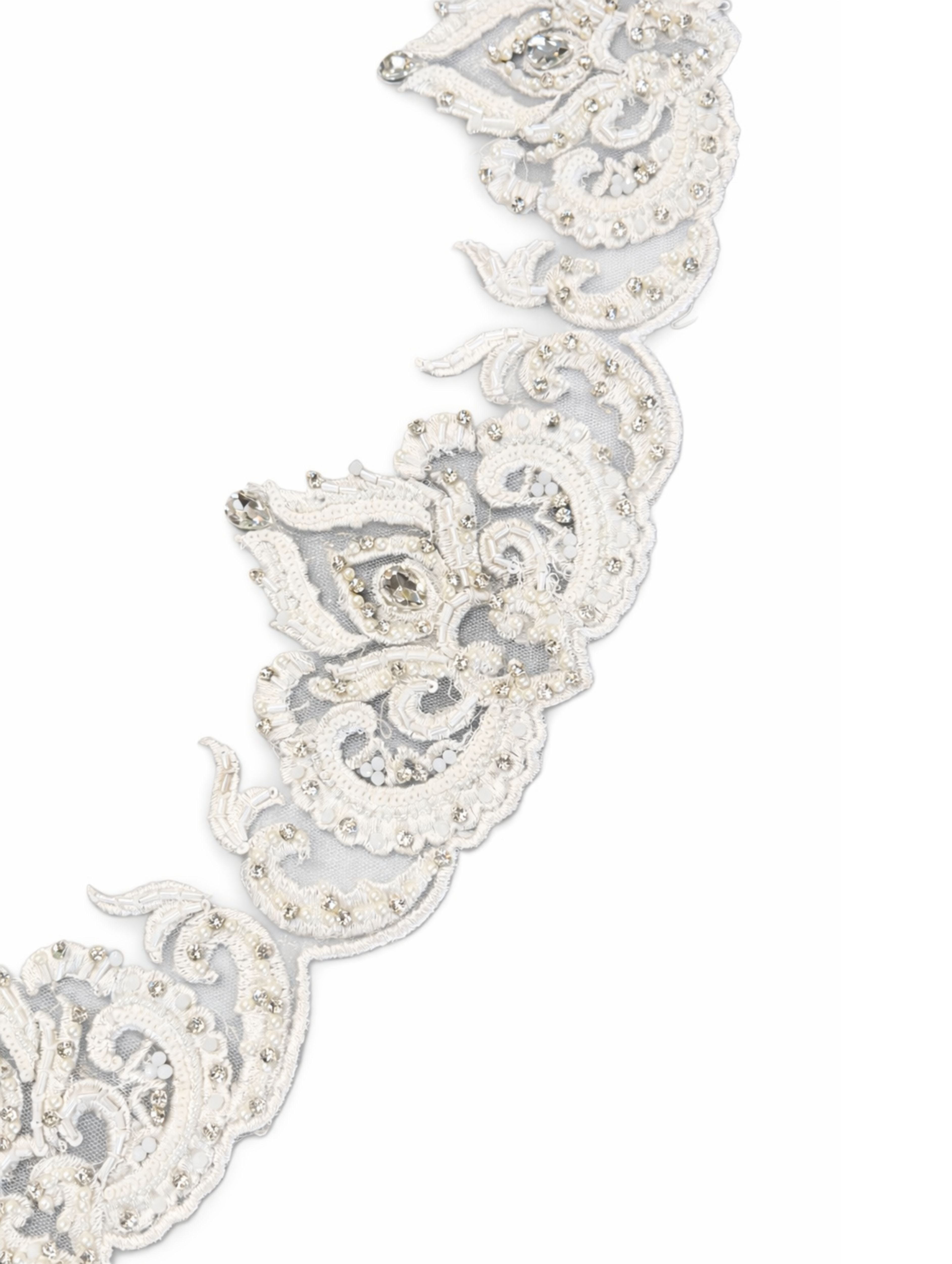 Detail van geborduurde rand van bruidssluier met parels, kralen en steentjes op gebroken witte tule.