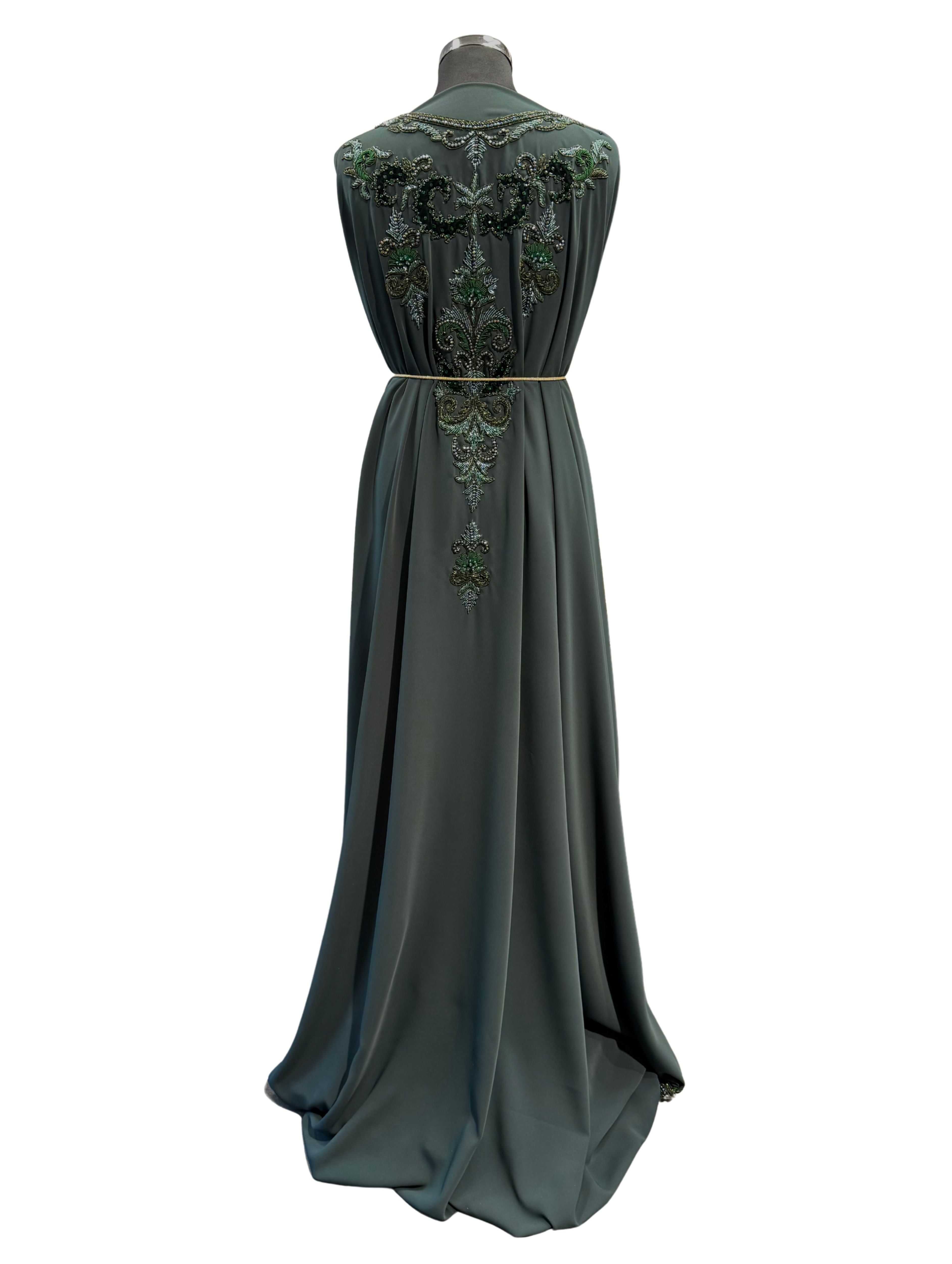 Achterkant van donker smaragdgroene crêpe stof voor takshita met soepel vallende structuur en egale afwerking.