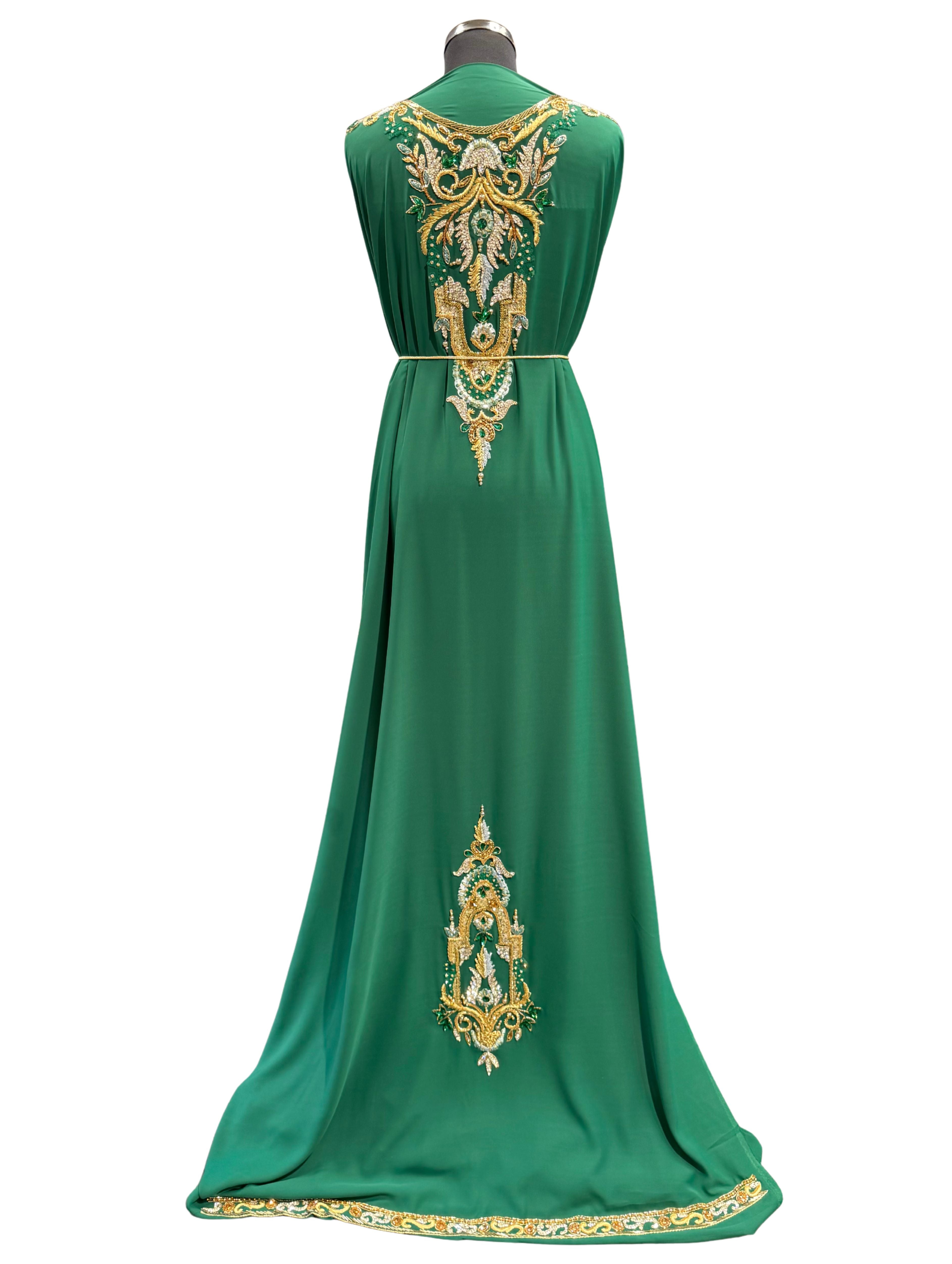 Achterkant van donkergroene soepel vallende crêpe stof met lichtblauw borduurwerk, steentjes en kraaltjes.