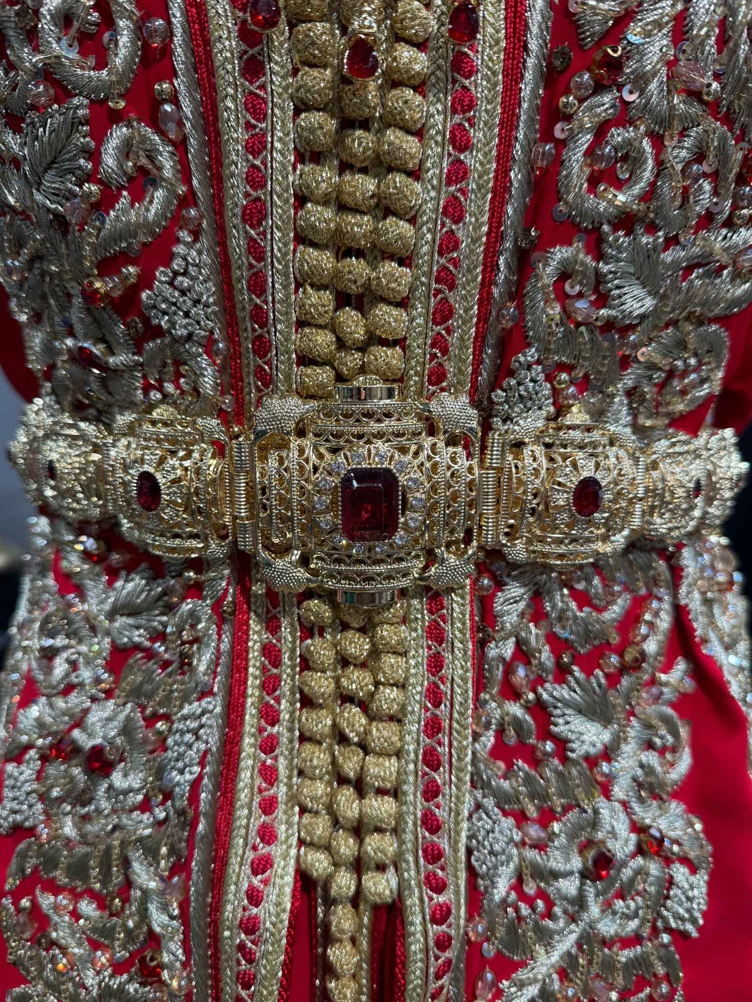 Marokkaanse Taqlidi riem in goud met rode steen, ideaal voor takshita of kaftan. Verstelbaar en stijlvol ontwerp.