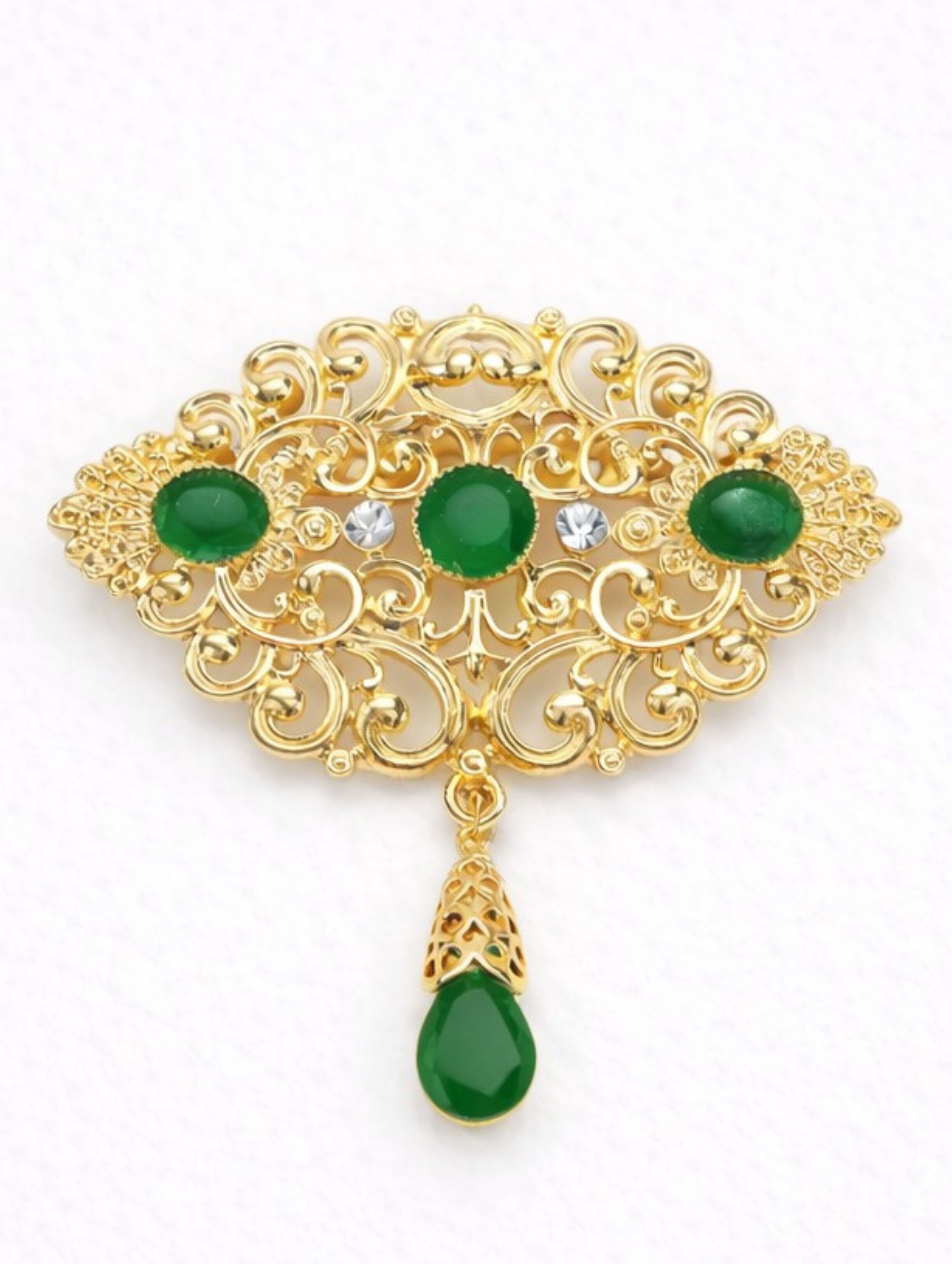 Gouden broche met donkergroene stenen in goudkleurige afwerking, stijlvol vormgegeven en geschikt voor zowel feestelijke als elegante gelegenheden.