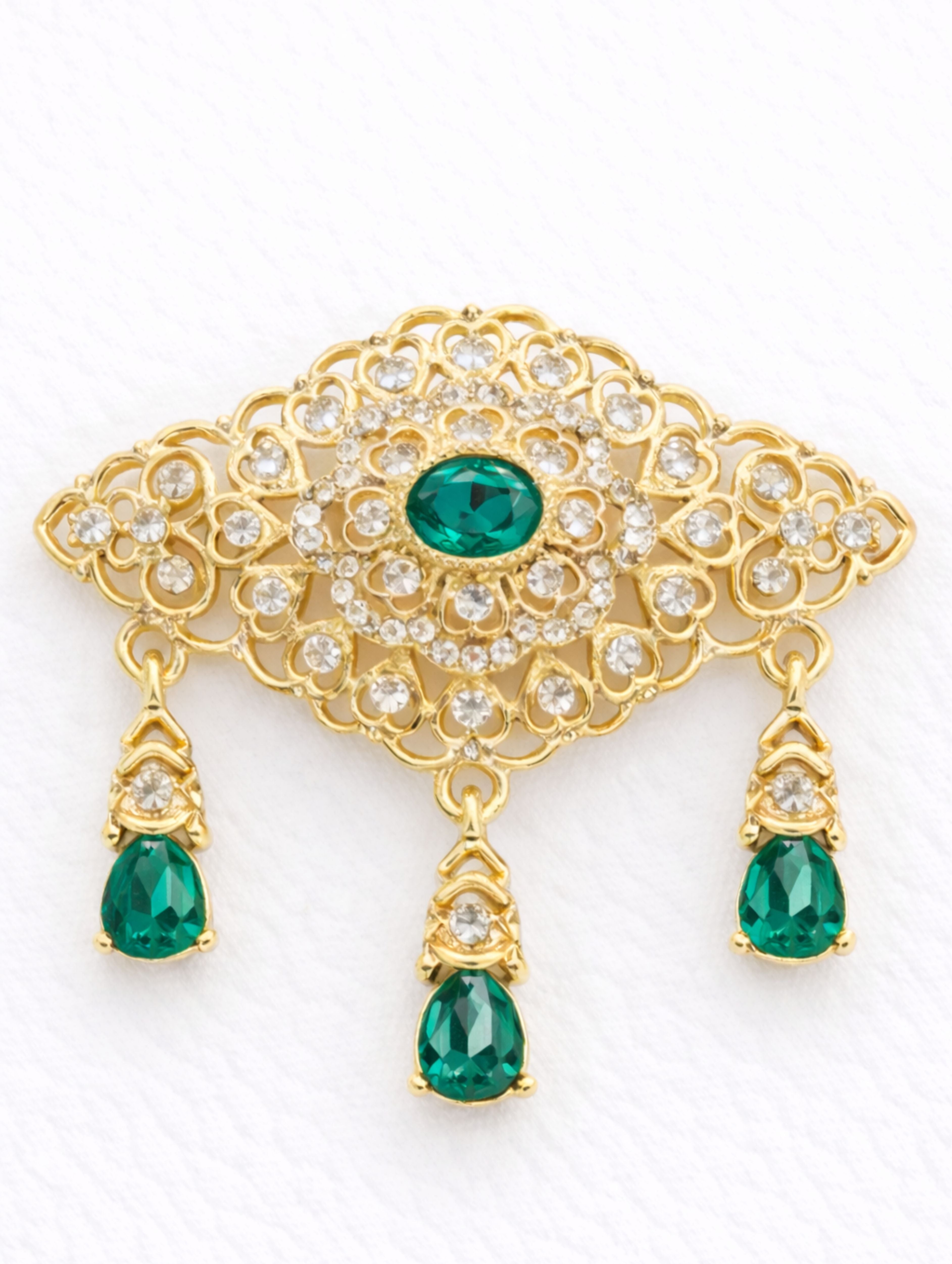 Gouden broche met donkergroene stenen in Marokkaanse stijl, uitgevoerd in goudkleurige afwerking en rijk gedetailleerd, geschikt voor feestelijke en elegante gelegenheden.