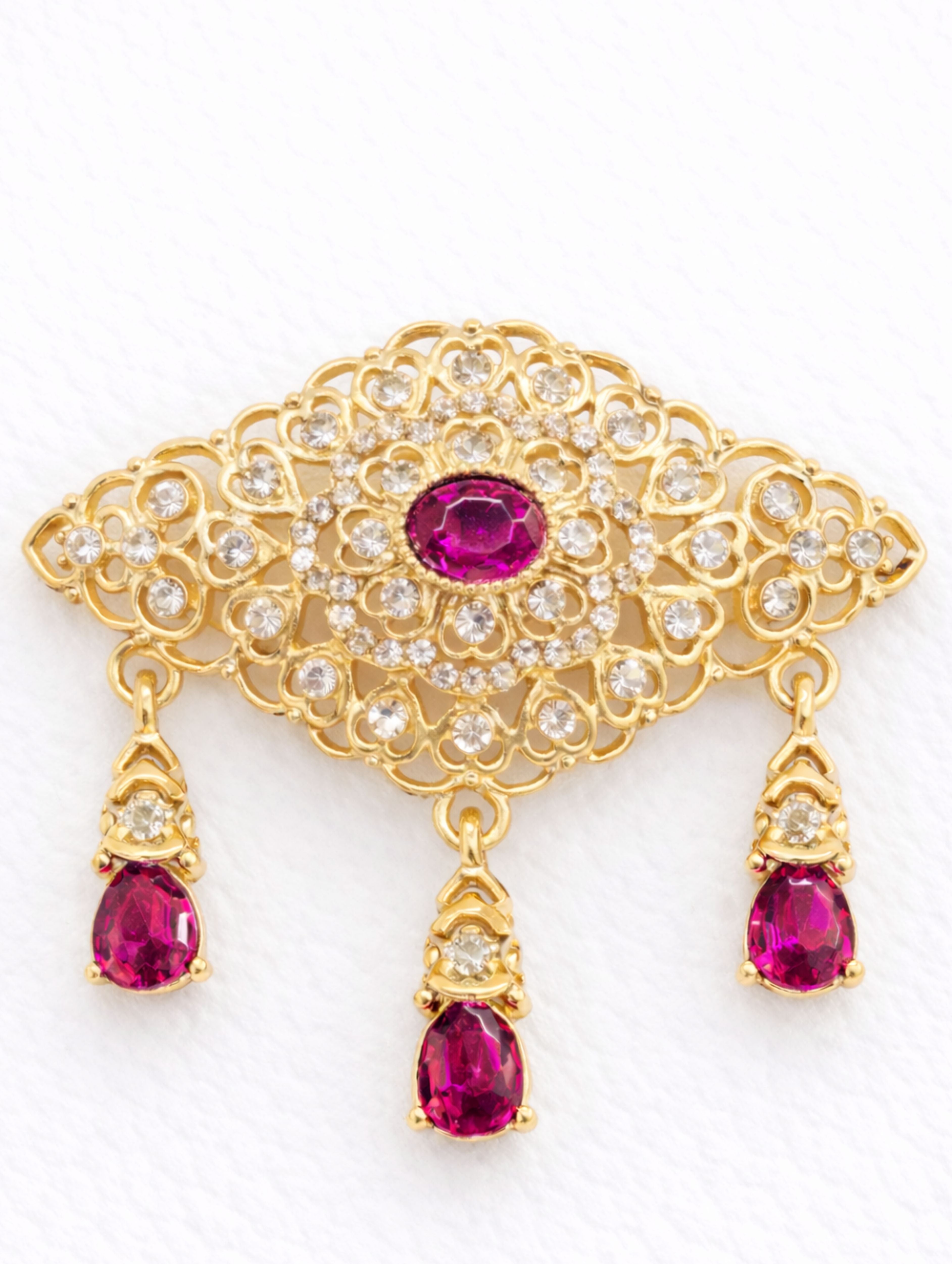 Gouden broche met fuchsia stenen in Marokkaanse stijl, uitgevoerd in goudkleurige afwerking met levendige fuchsiatinten, geschikt voor feestelijke en stijlvolle gelegenheden.