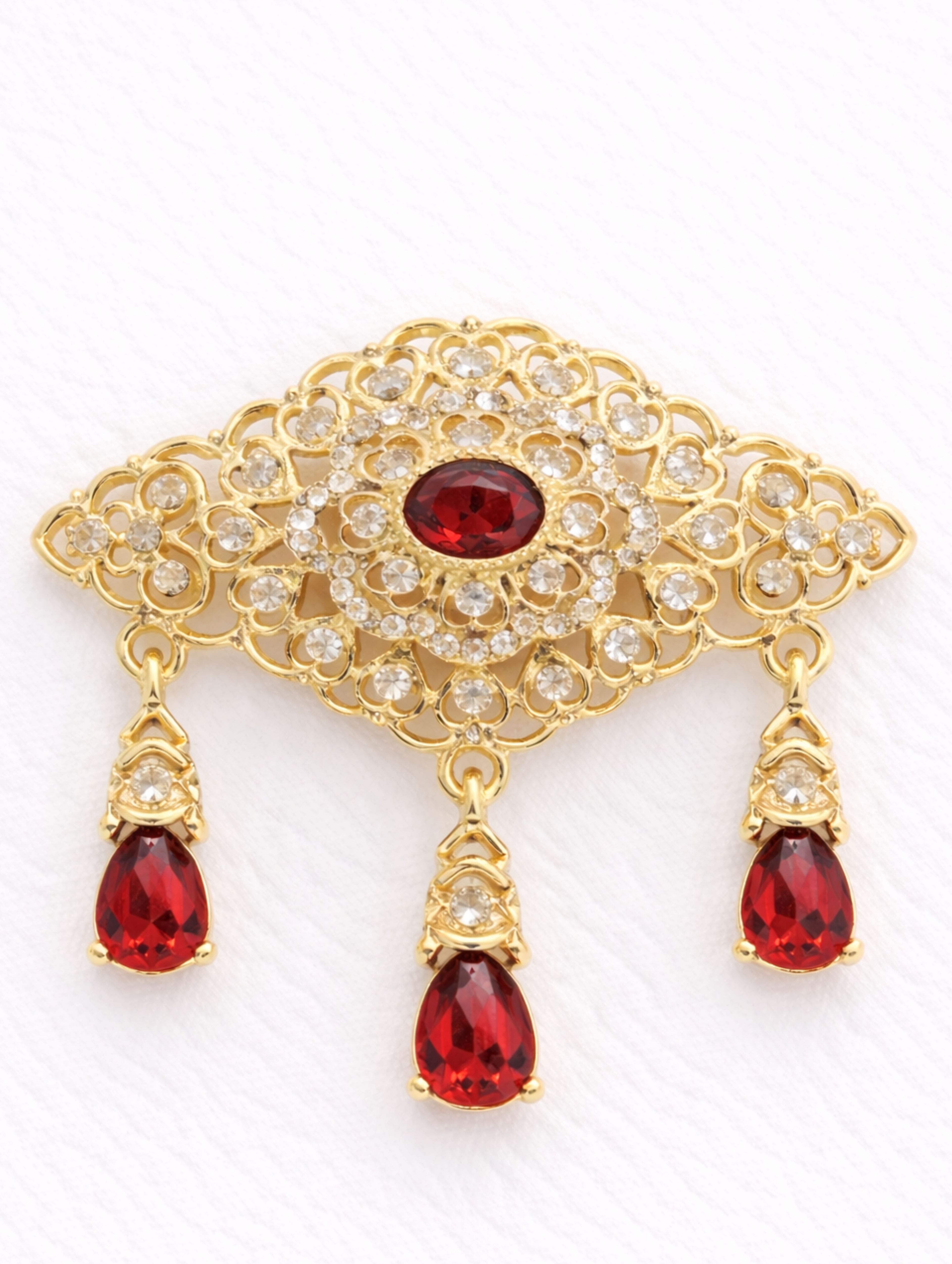Gouden broche met rode stenen in Marokkaanse stijl, uitgevoerd in goudkleurige afwerking met diep rode stenen, geschikt voor feestelijke en stijlvolle gelegenheden.