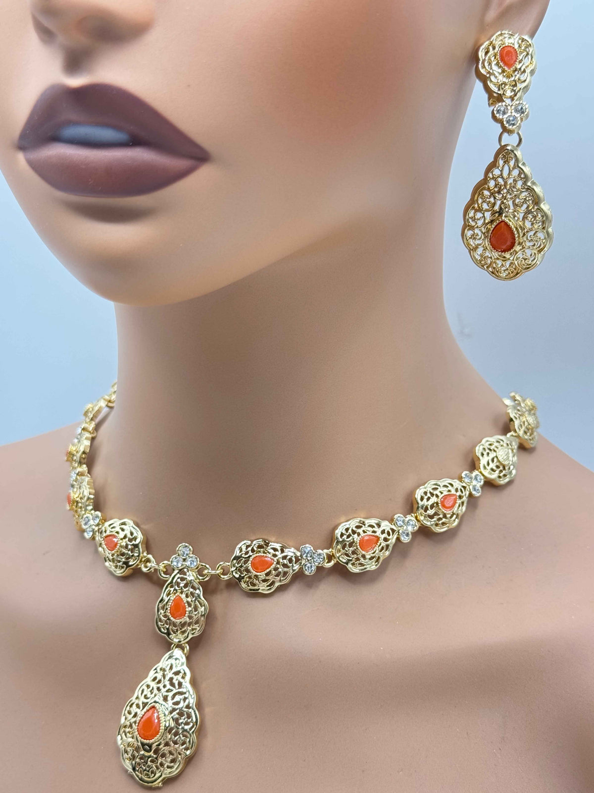 Gouden Marokkaanse sieradenset met terracotta stenen, bestaande uit een in lengte verstelbare ketting en bijpassende oorbellen.