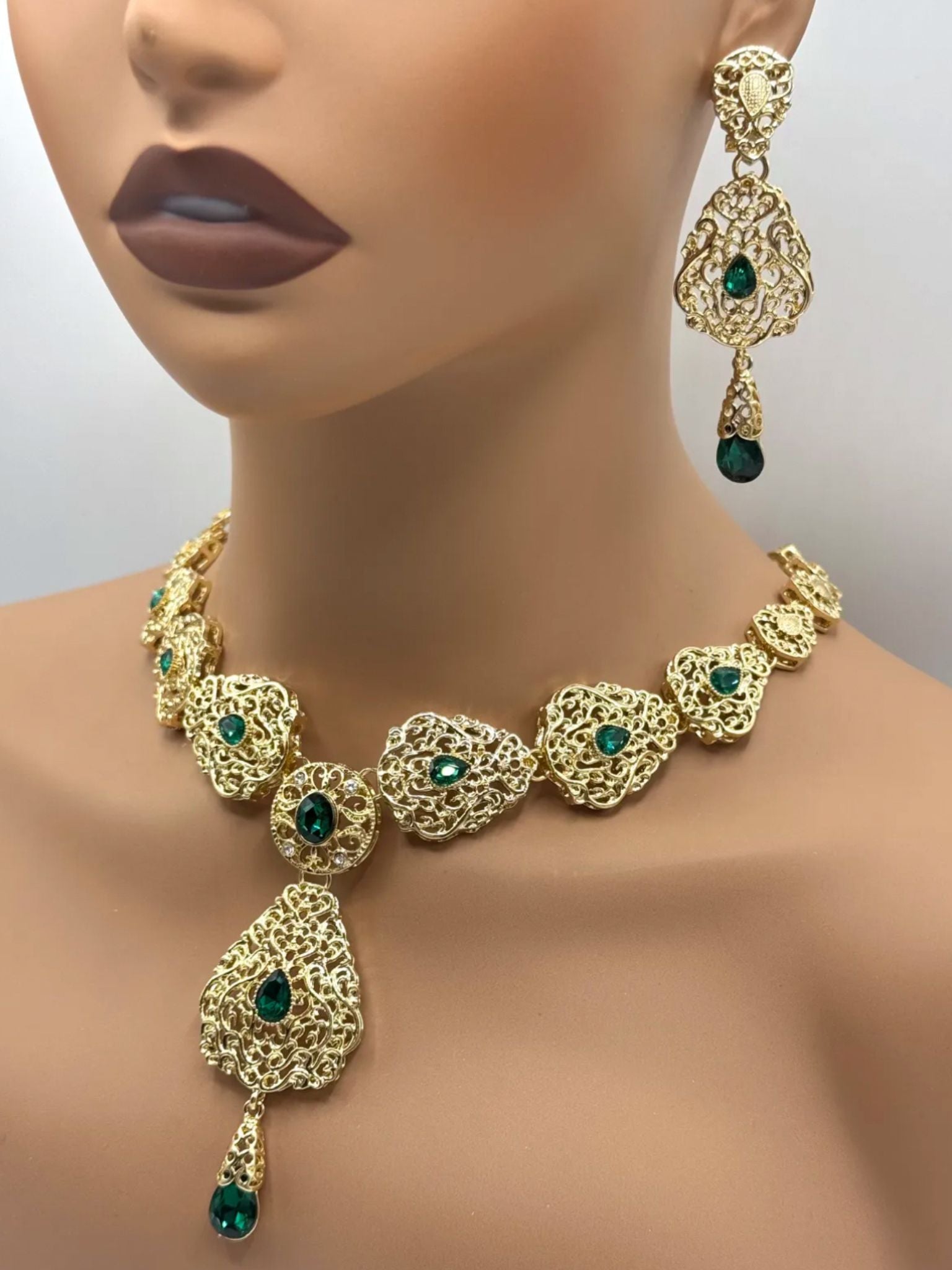 Gouden ketting met bijpassende oorbellen met donker groene stenen, voor takshita of feestkleding.