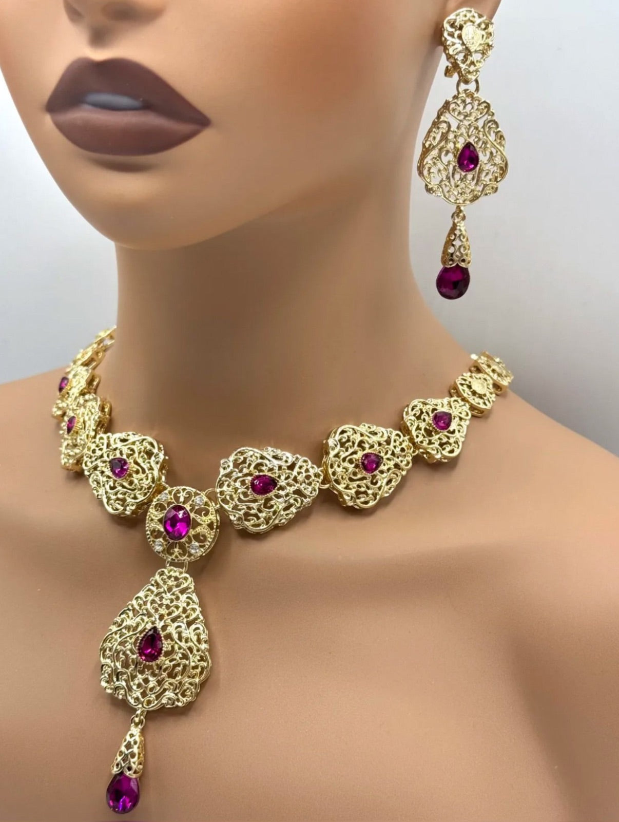 Elegante gouden ketting met oorbellen met fuchsia stenen, ideaal bij een takshita of feestelijke outfit.