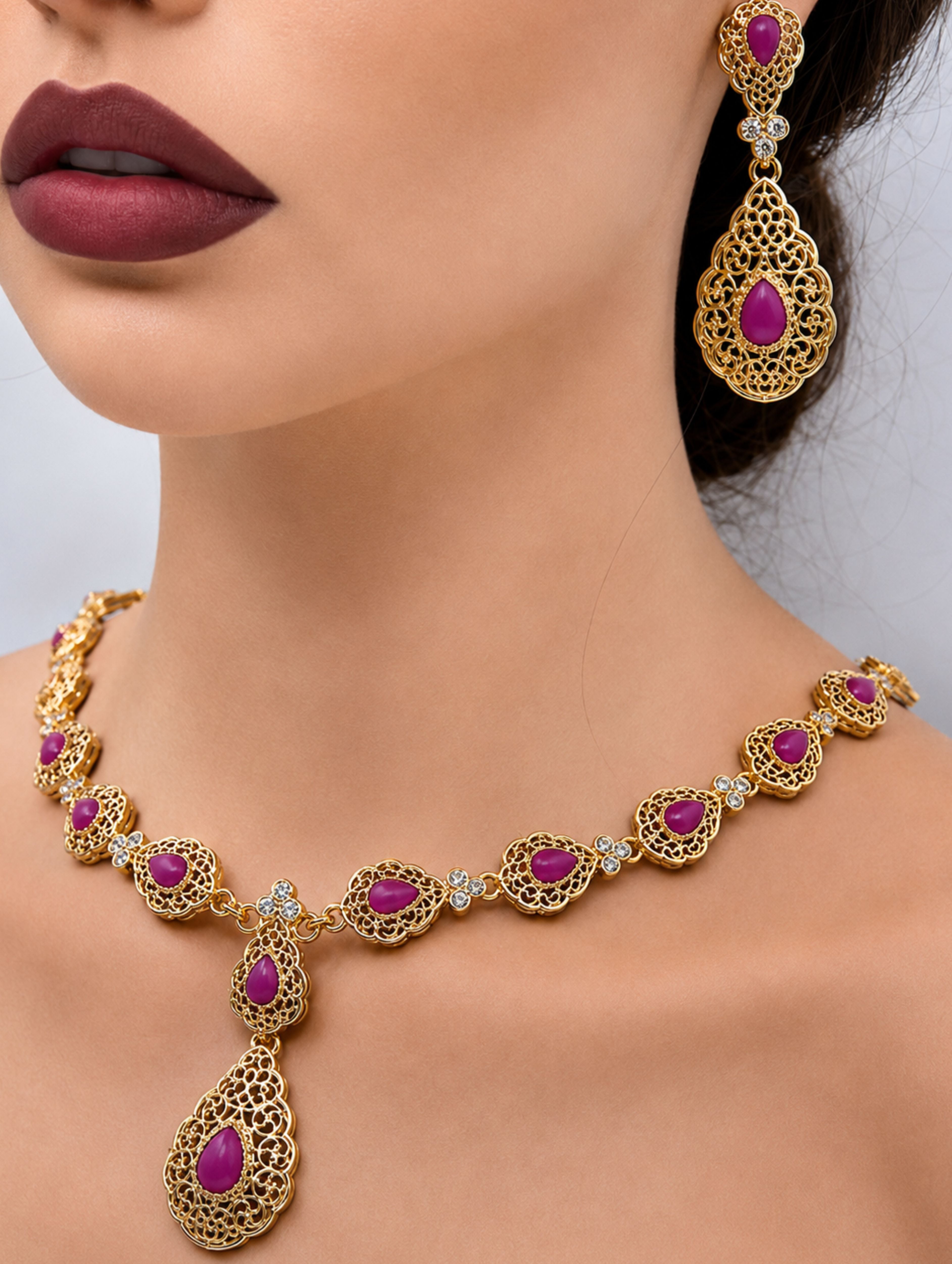 Gouden ketting met magenta stenen met bijpassende oorbellen