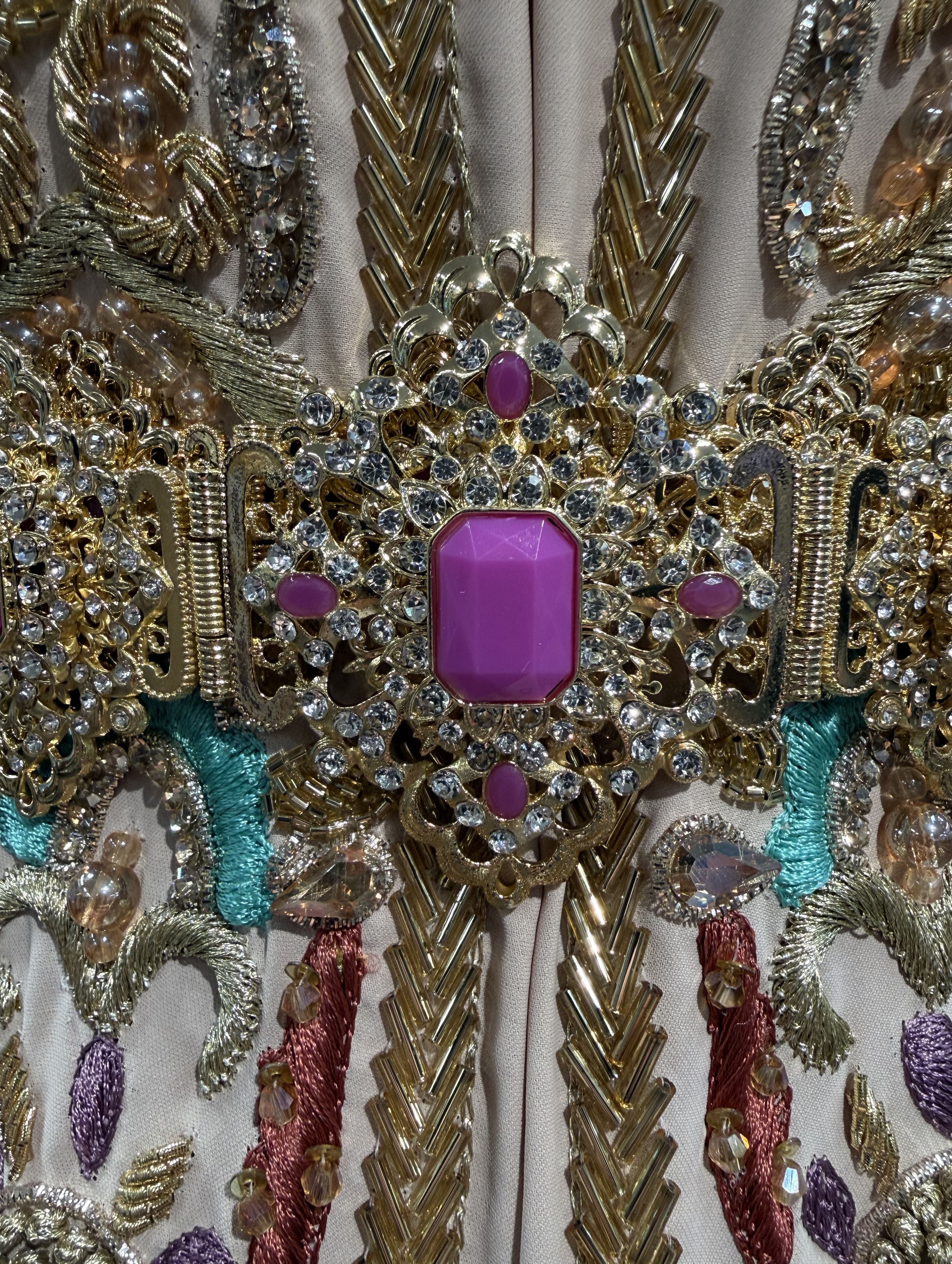 Detailopname van magenta stenen op een gouden riem