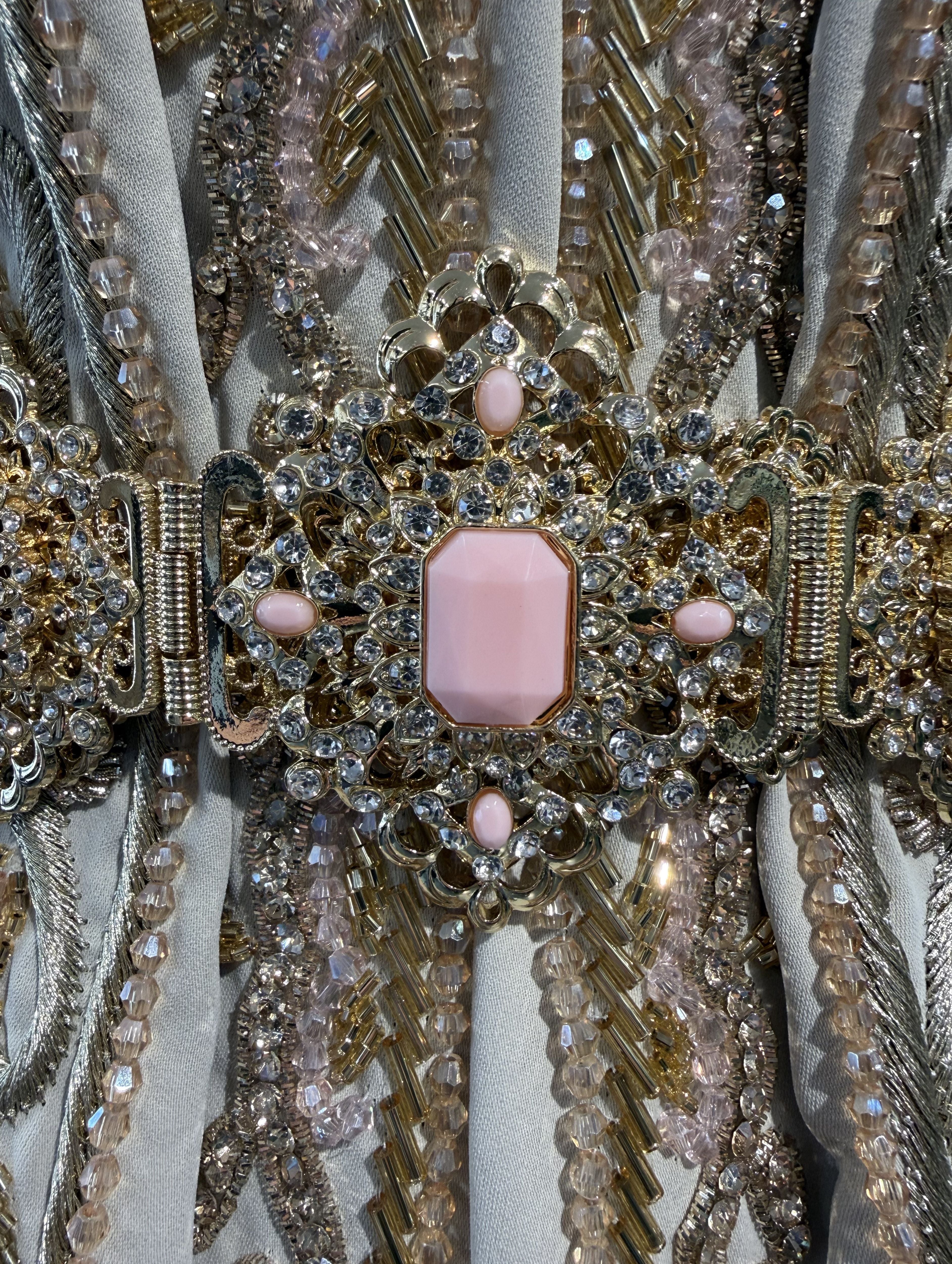Close-up van zachtroze stenen op gouden riem