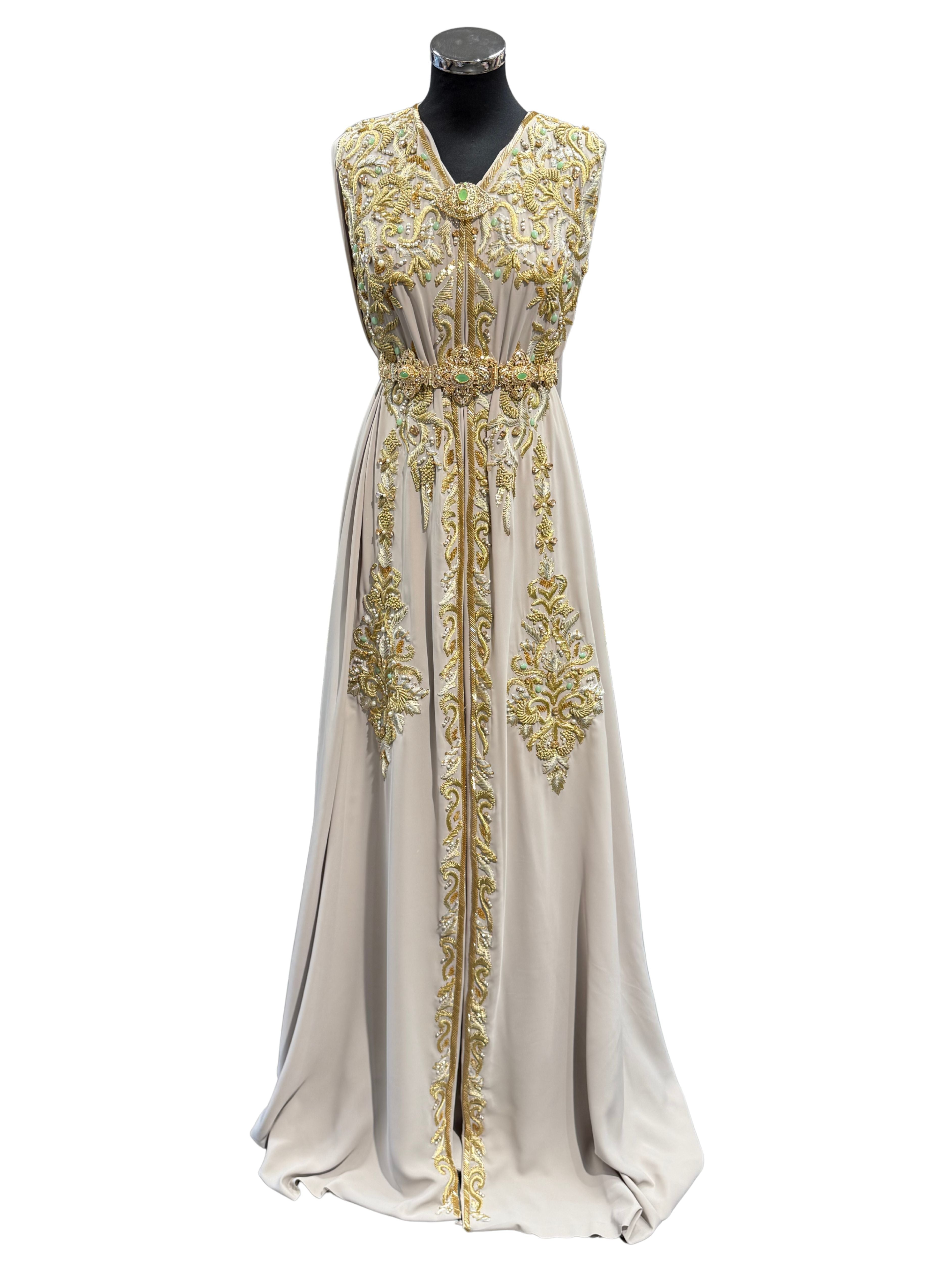 Voorkant van grijsbeige soepel vallende crêpe stof, rijk bewerkt met goudkleurig borduurwerk en mintgroene kralen.