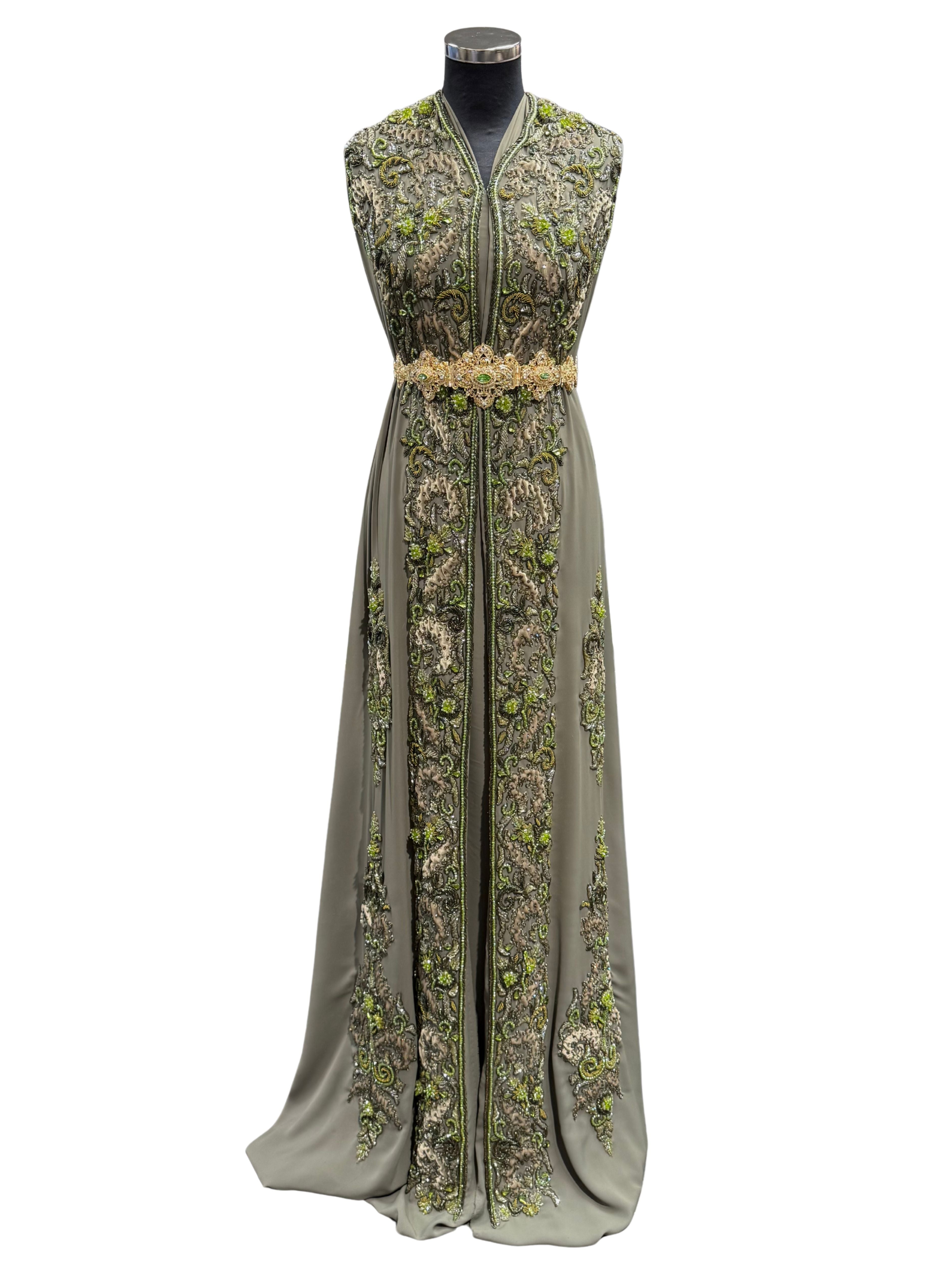 Voorkant van mosgroene soepel vallende crêpe stof met tone-sur-tone bewerking van kralen, stenen en velours patches.