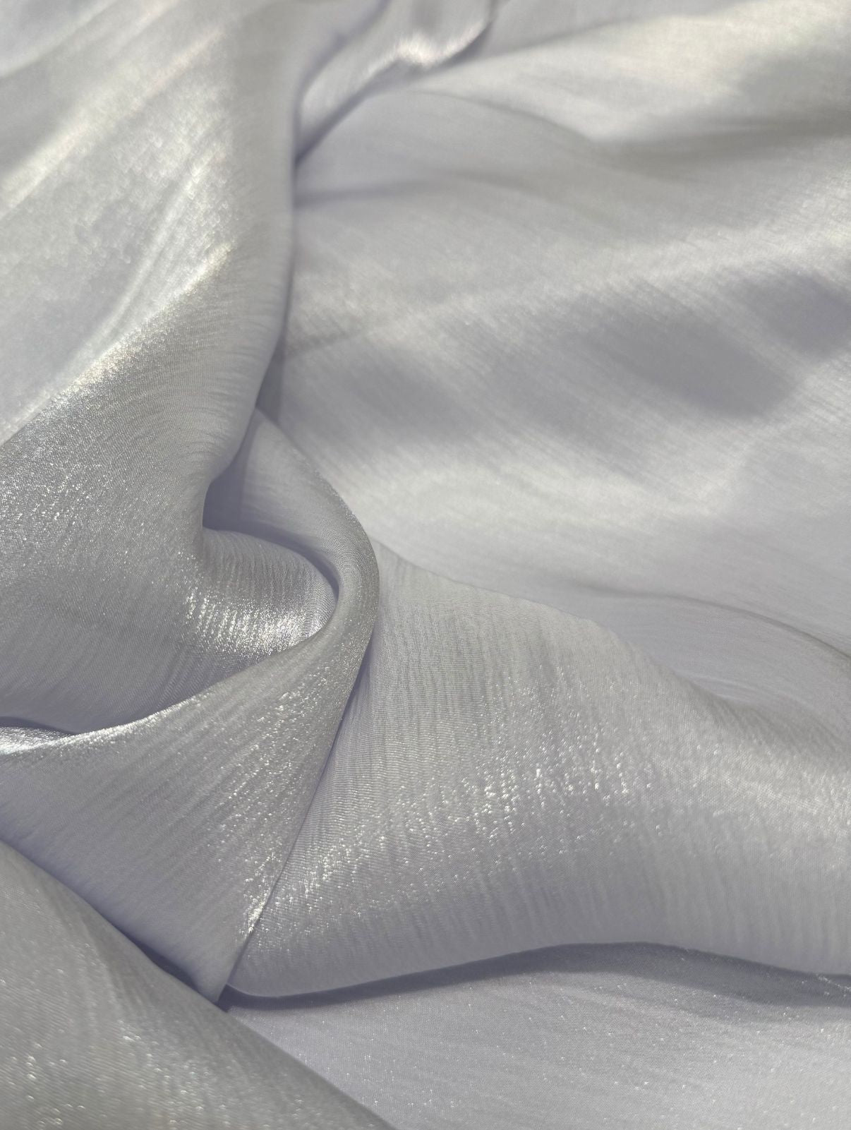 Licht grijze organza stof met subtiele glans, soepel vallend en ideaal voor takshita of feestkleding.