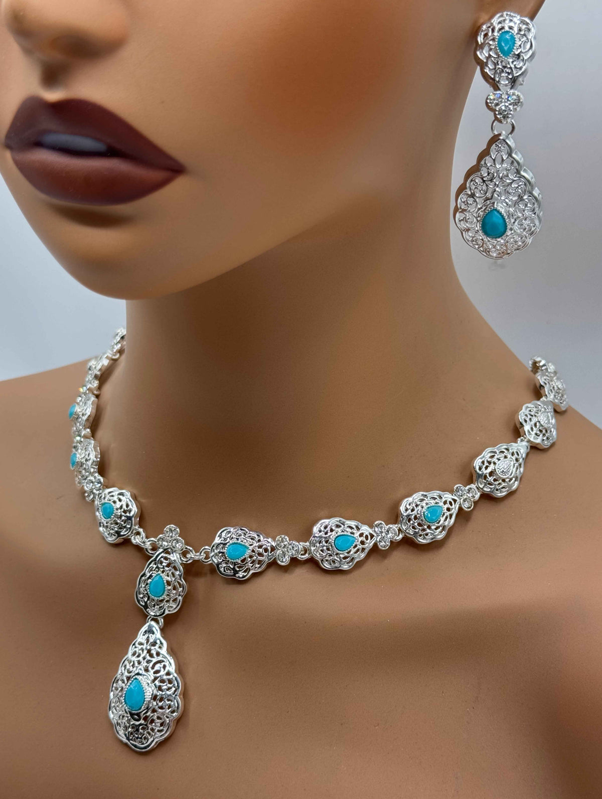 Parure marocaine argentée avec pierres bleu aqua et boucles d’oreilles assorties. Le collier est réglable en longueur et convient à une takchita, un caftan ou une tenue de fête.