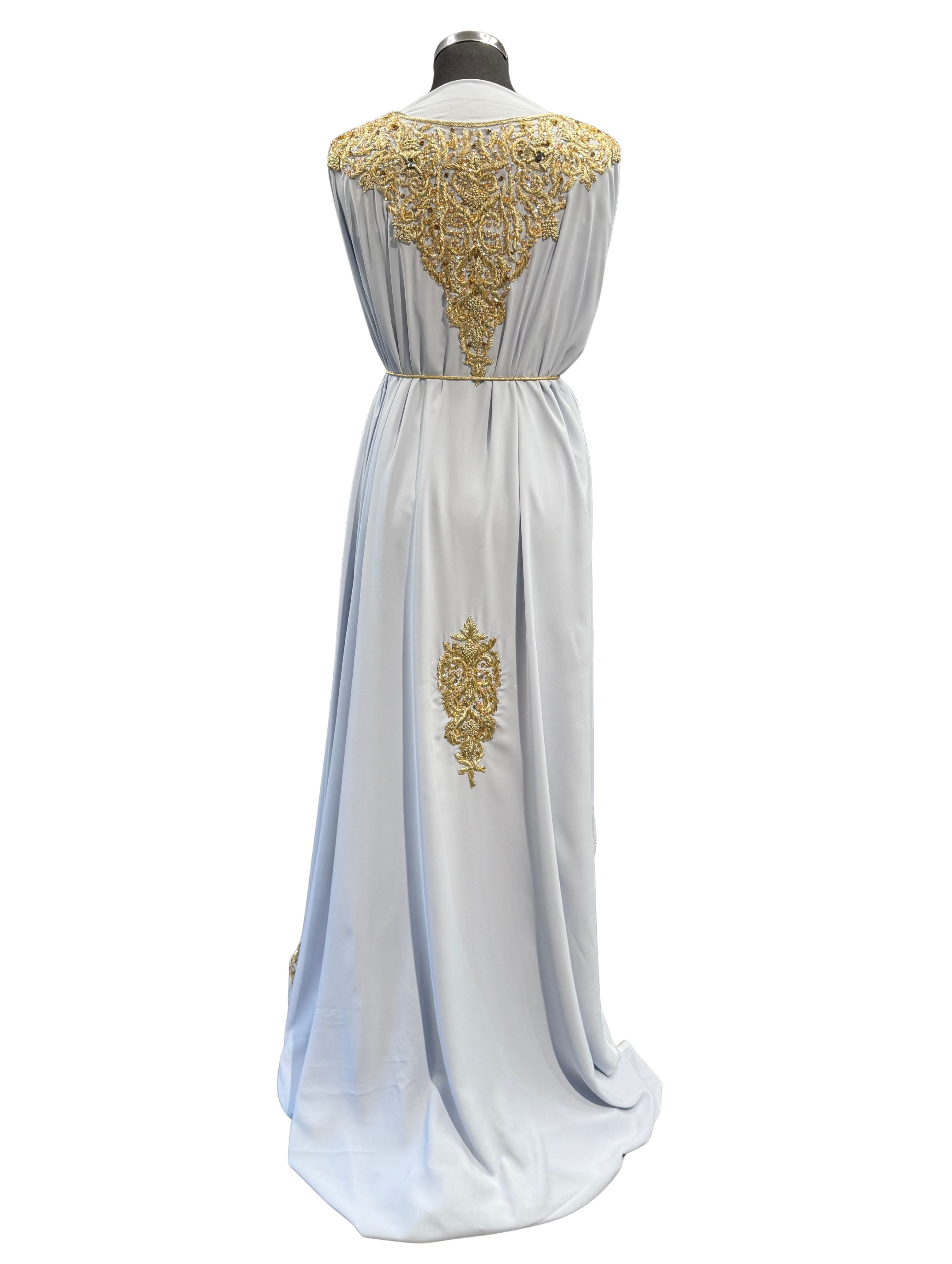 Achterkant van lichtblauwe takshita stof, verfijnd afgewerkt met elegant gouden borduurwerk.