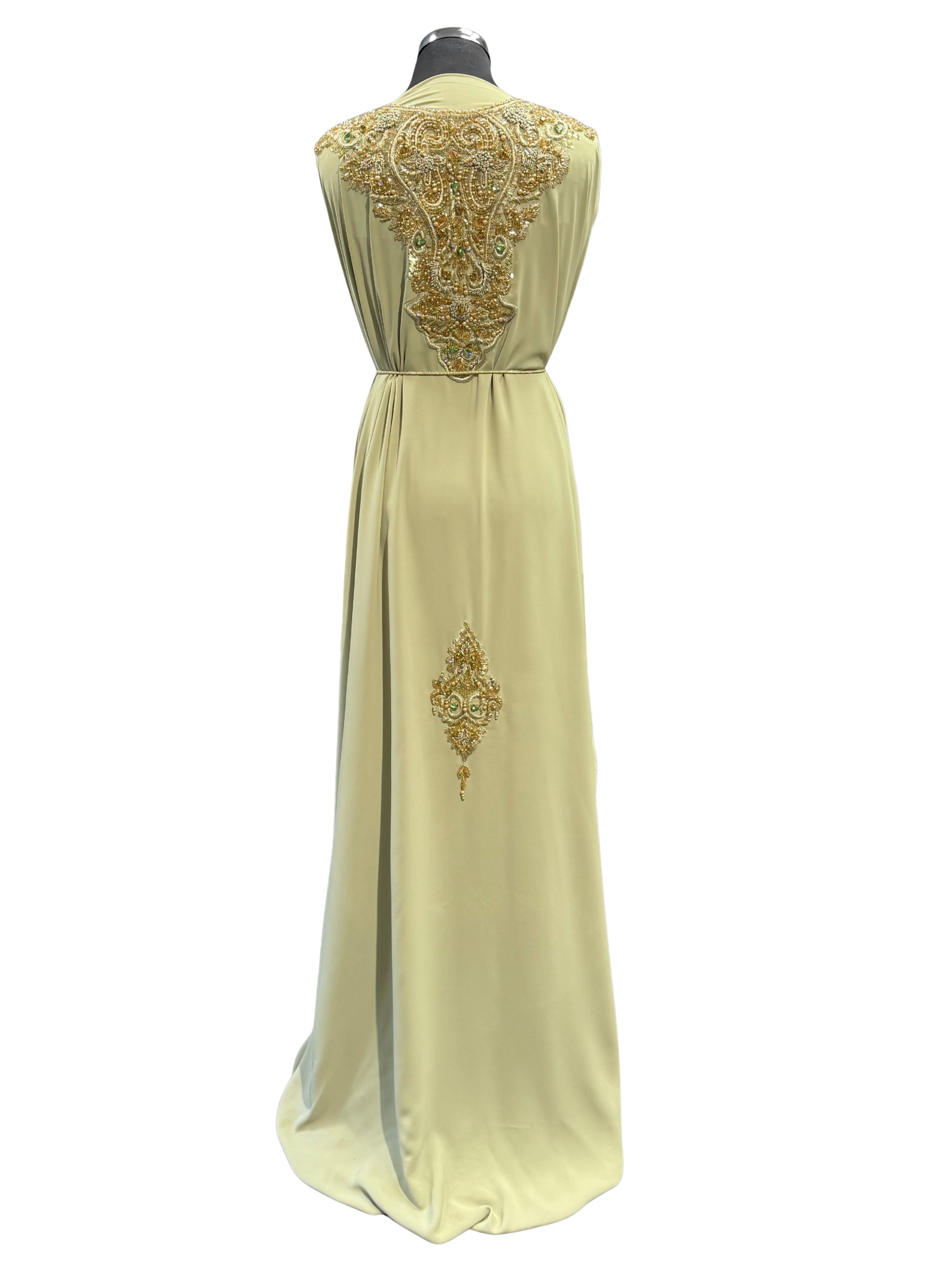 Achterkant van pistache takchita stof van crepe kwaliteit, bewerkt met gouden accenten, glanzende kralen en fonkelende stenen. De onderstof is pistache crepe.