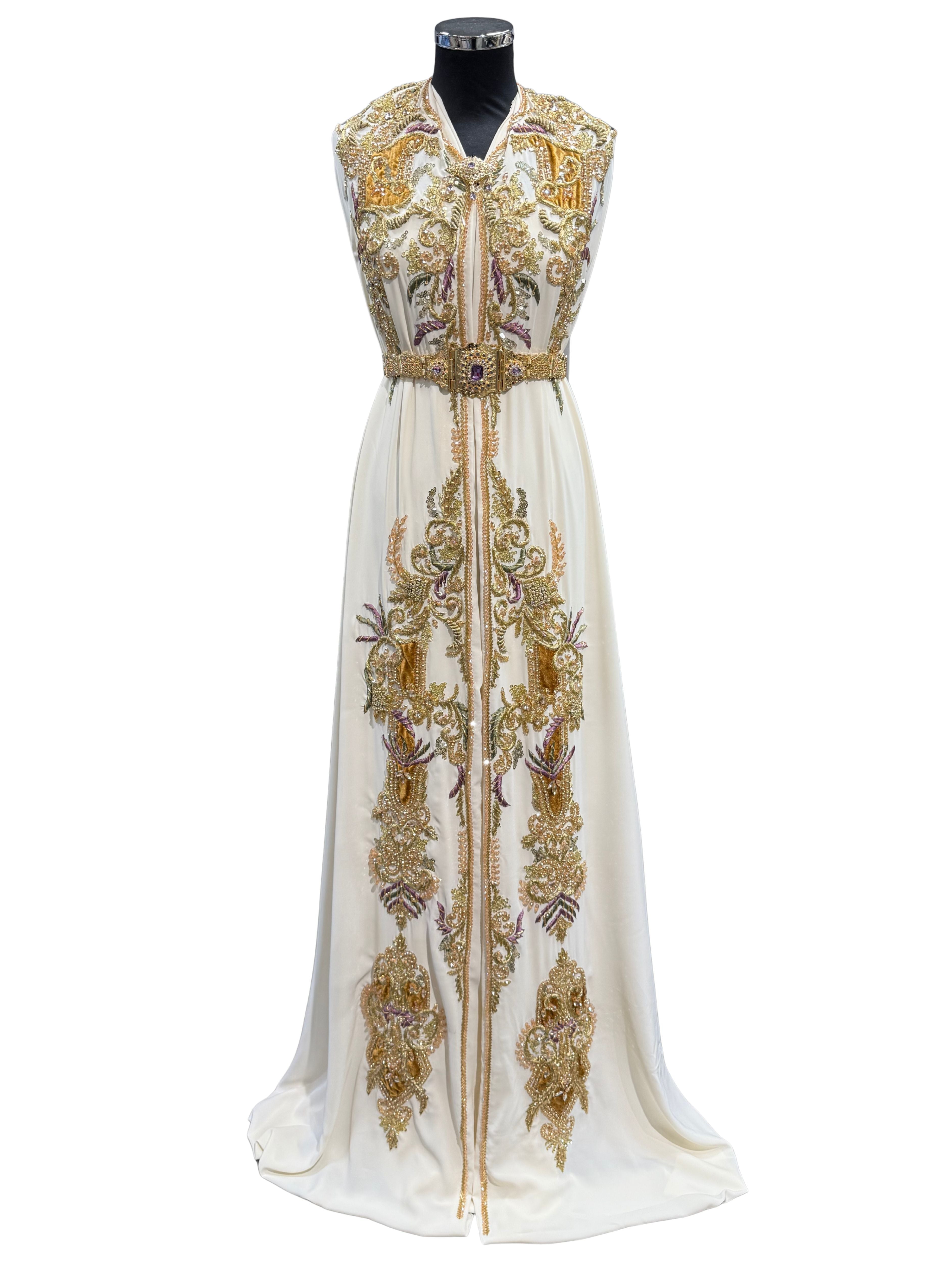 Voorkant van crème takshita stof van crepe kwaliteit, bewerkt met gouden accenten, velours patches en paarse en groene borduurwerk. De onderstof is crème crepe.