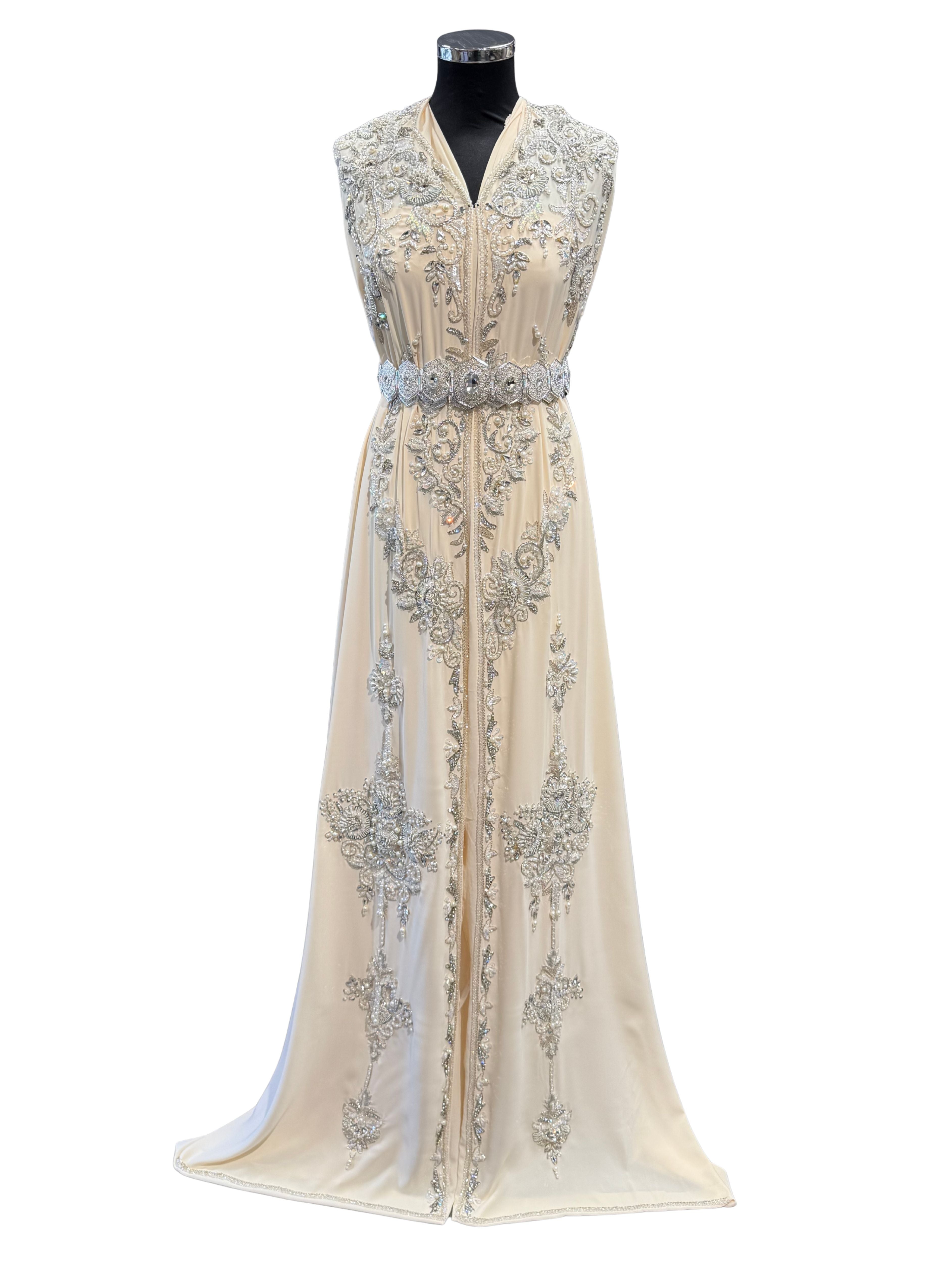 Voorkant van ivoorcrème takshita stof, verfijnd bewerkt met zilverkleurige accenten, kraaltjes en steentjes.