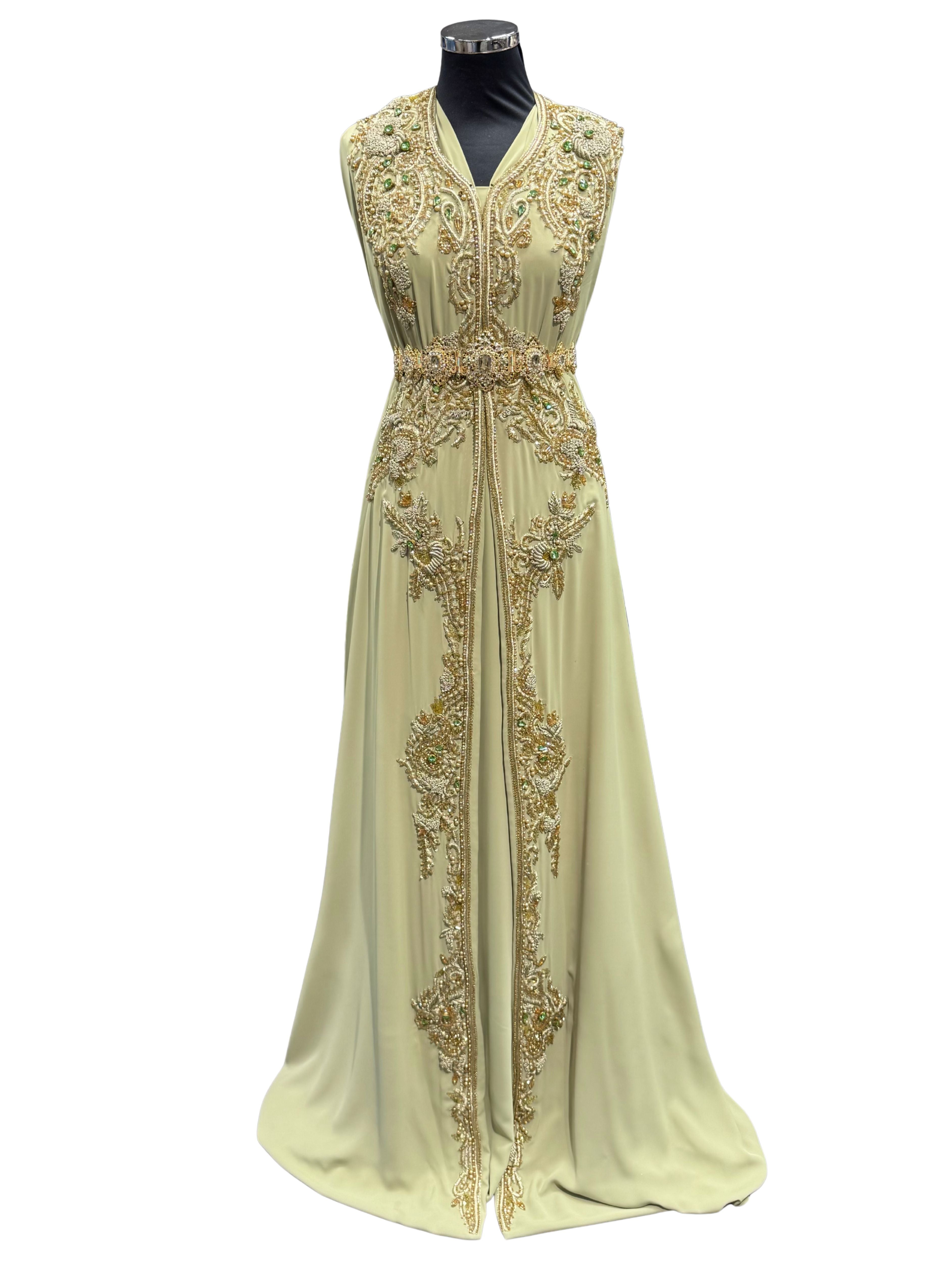 Voorkant van pistache takshita stof van crepe kwaliteit, bewerkt met gouden borduurwerk en fonkelende stenen. De onderstof is pistache crepe.