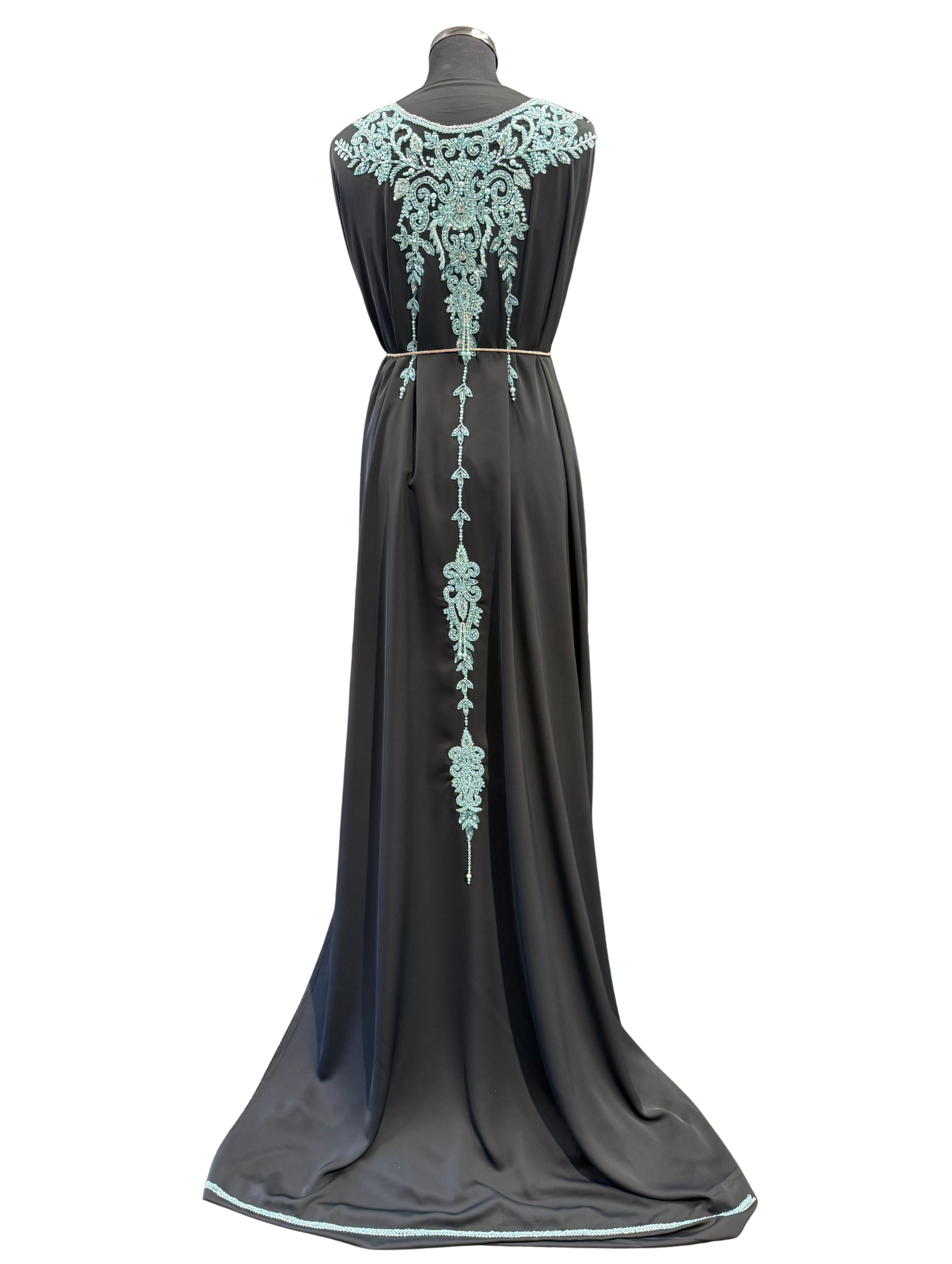 Achterkant van zwarte takshita stof van crepe kwaliteit, bewerkt met lichtblauwe kralen en parels. De onderstof is zwarte crepe.