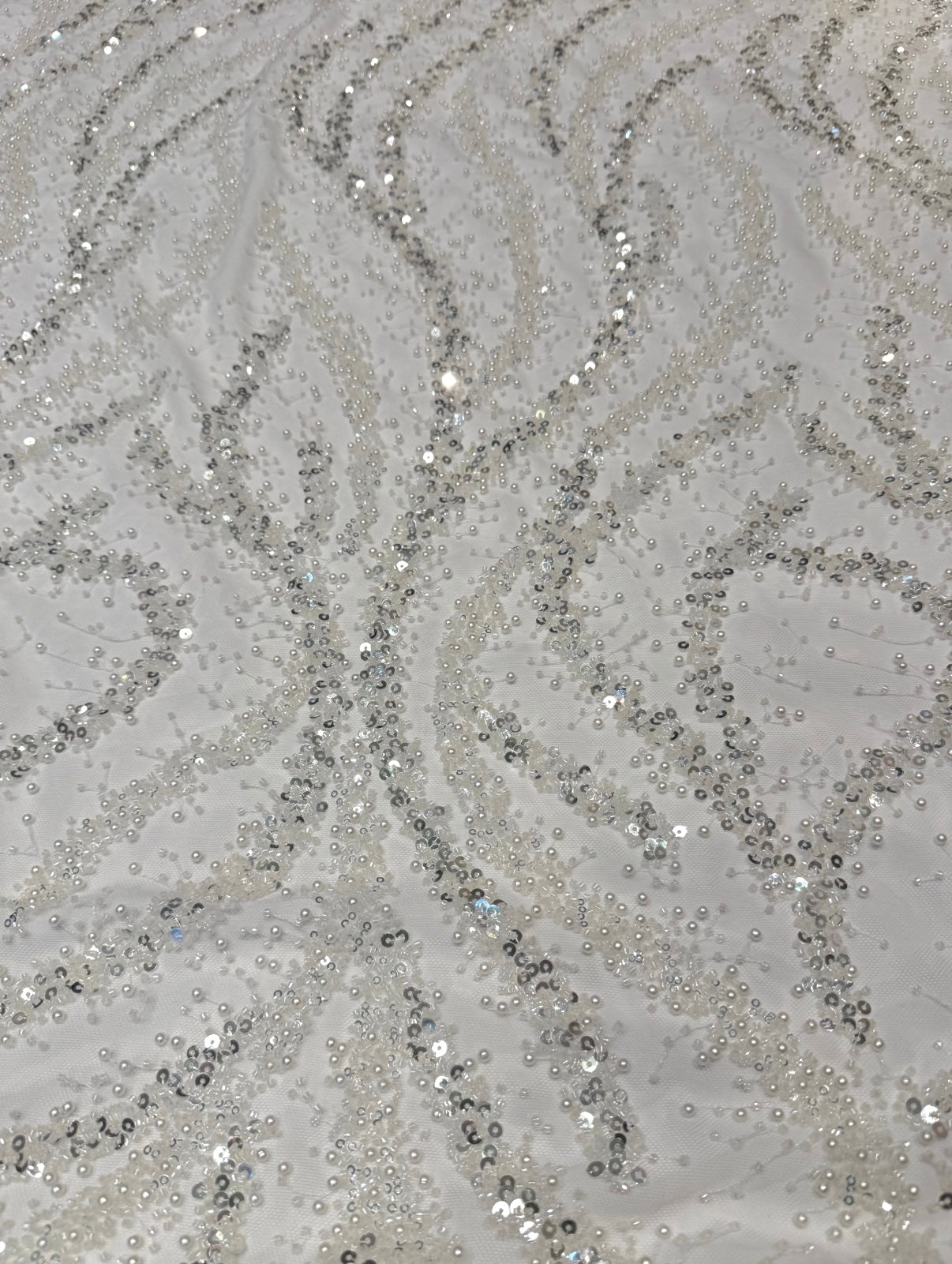 Kanten stof in de kleur wit met kralen en parels