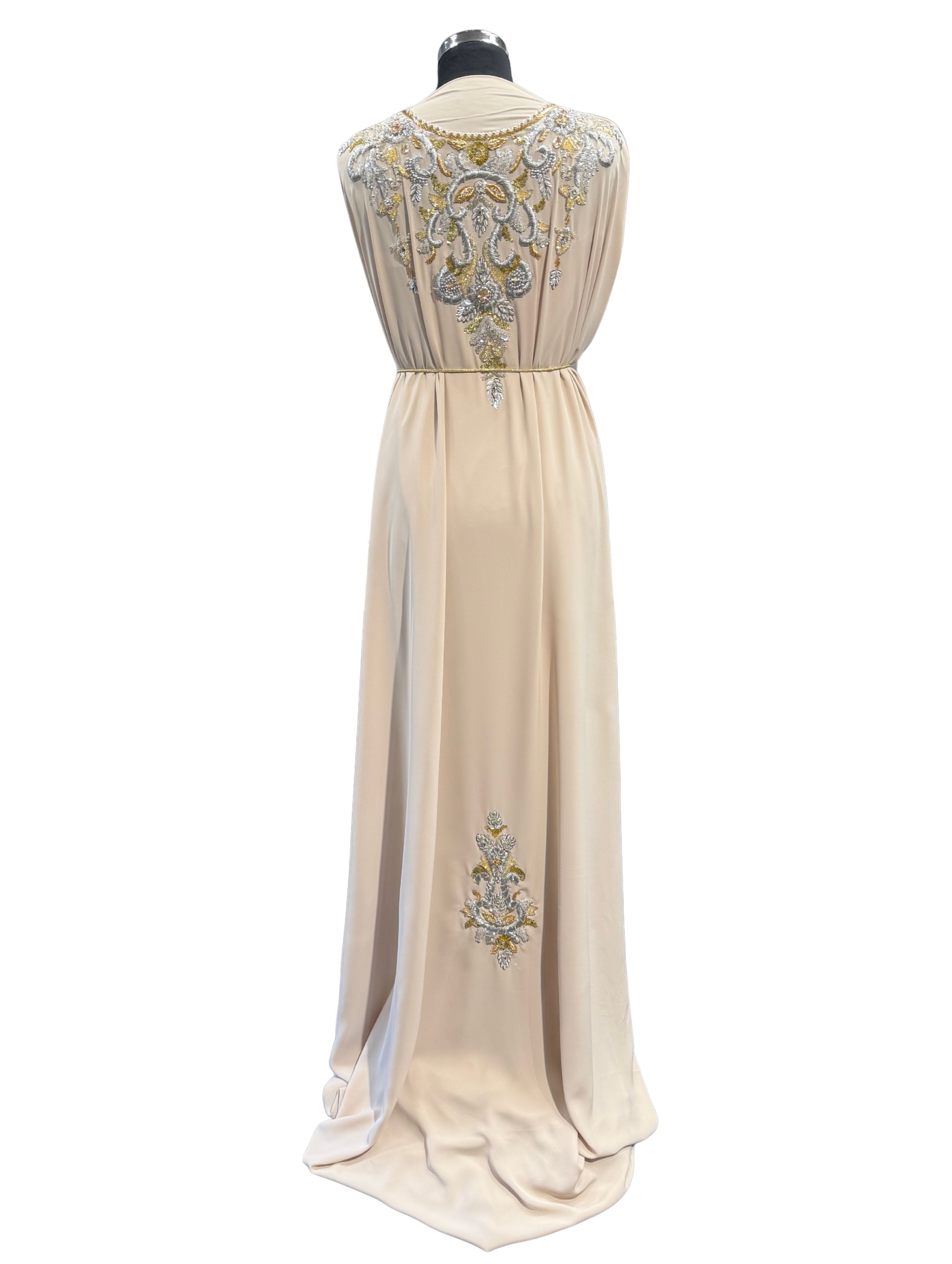 Achterkant van beige crepe stof met subtiele gouden en zilverkleurige bewerking, geschikt voor feestelijke kleding.