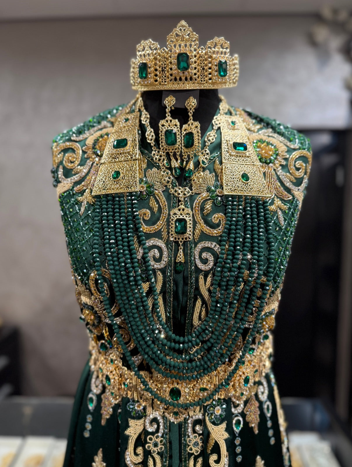 Marokkaanse bruidssieraad set goud met donkergroene stenen, inclusief kroon, hoofdketting, oorbellen, ketting en lange ketting met kralen.