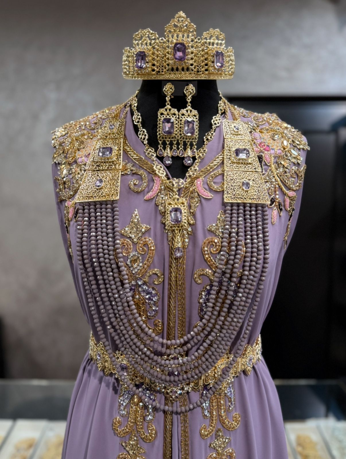 Marokkaanse bruidssieraden goud met paarse stenen, inclusief kroon, hoofdketting, oorbellen, ketting en lange ketting met kralen.