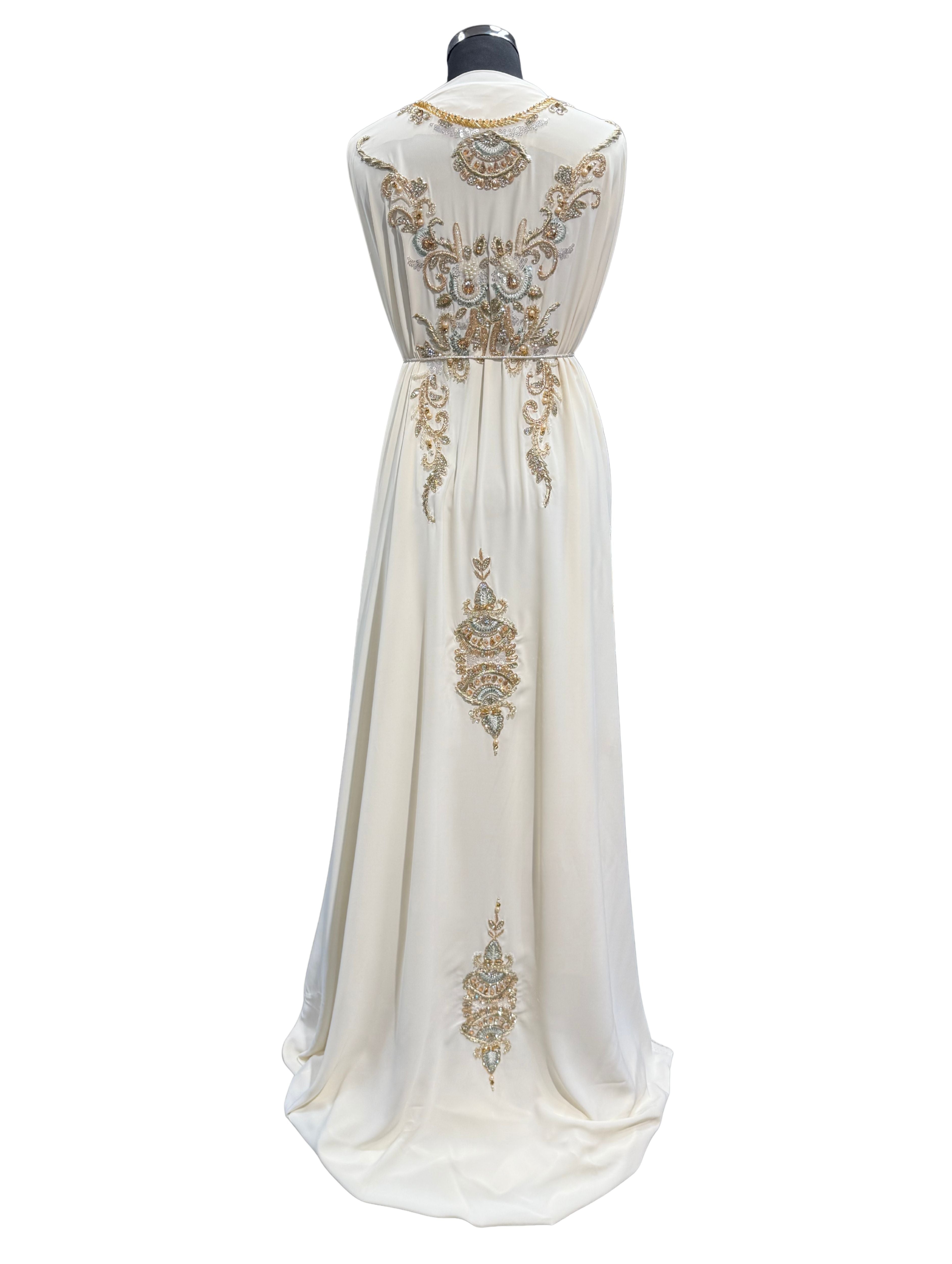 Achterkant van crème caftan of takshita stof met parels, kralen en steentjes op boven- en onderstof.