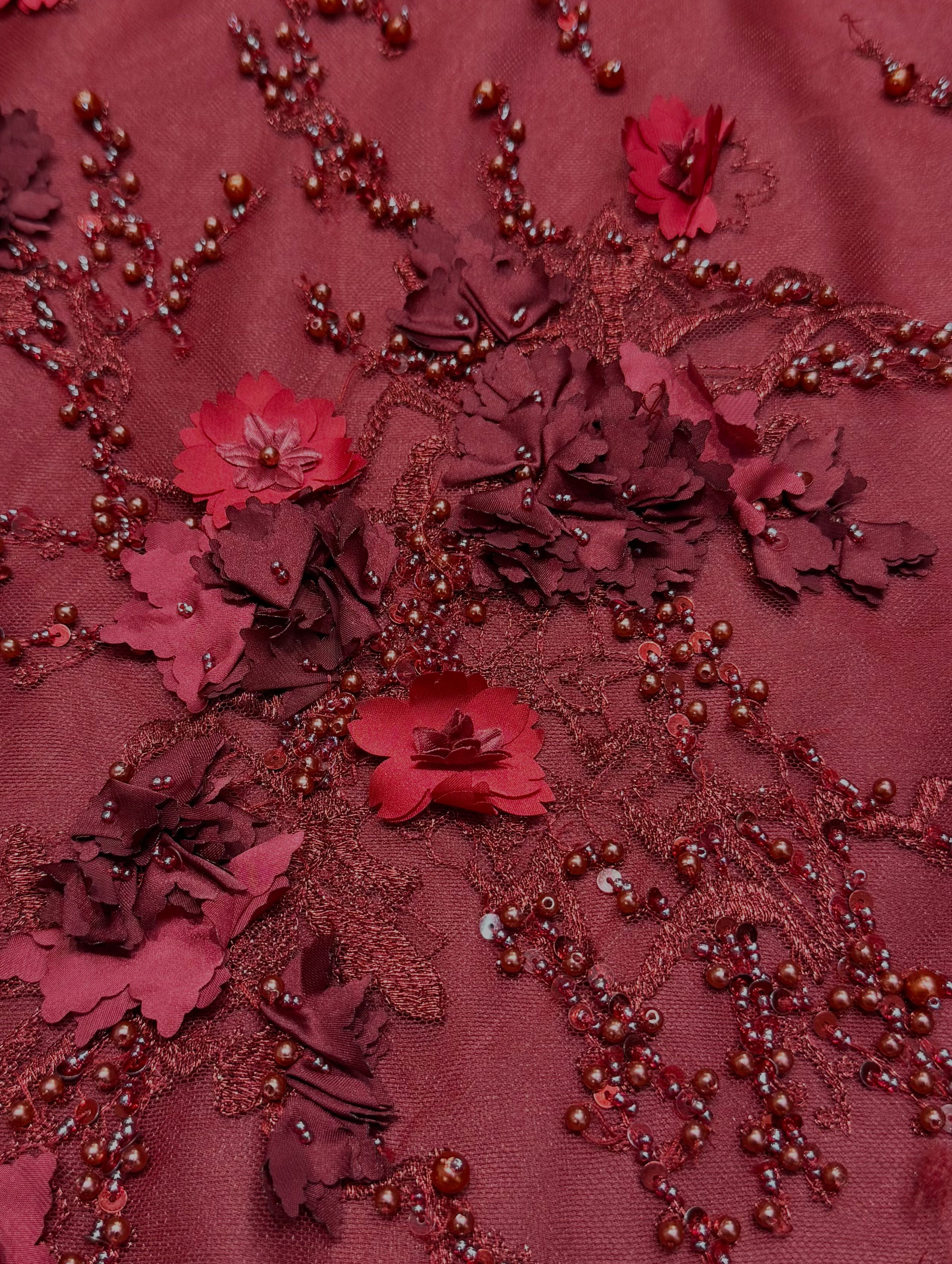 Detailfoto van bordeaux kant stof met 3D bloemen, zichtbaar patroon en textuur, ideaal voor avondjurk en traditionele kleding