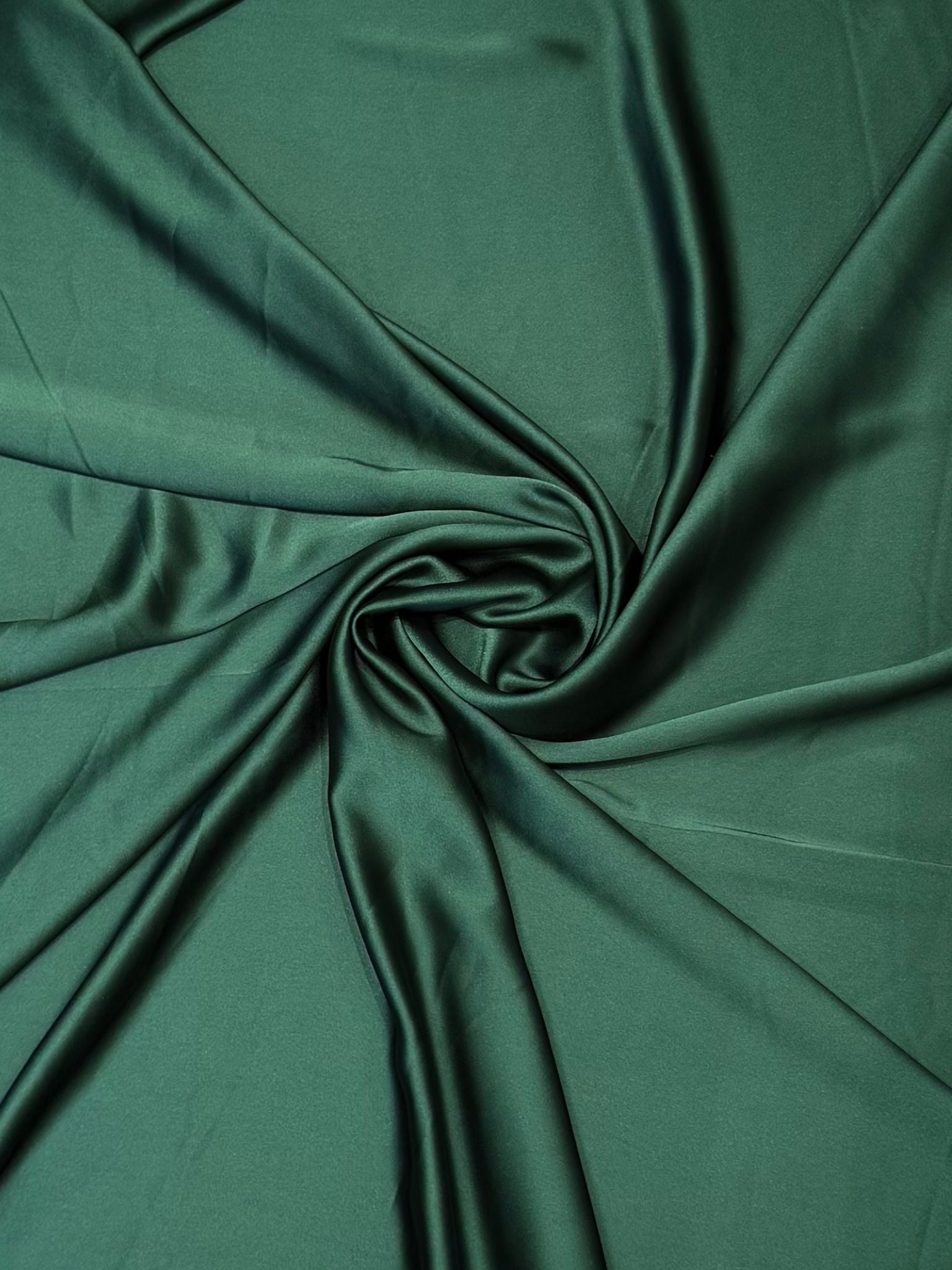 Donkergroene crepe satijn stof met luxe zijdeglans en soepelvallende kwaliteit, geschikt voor caftans, takshita's en exclusieve kledingstukken.