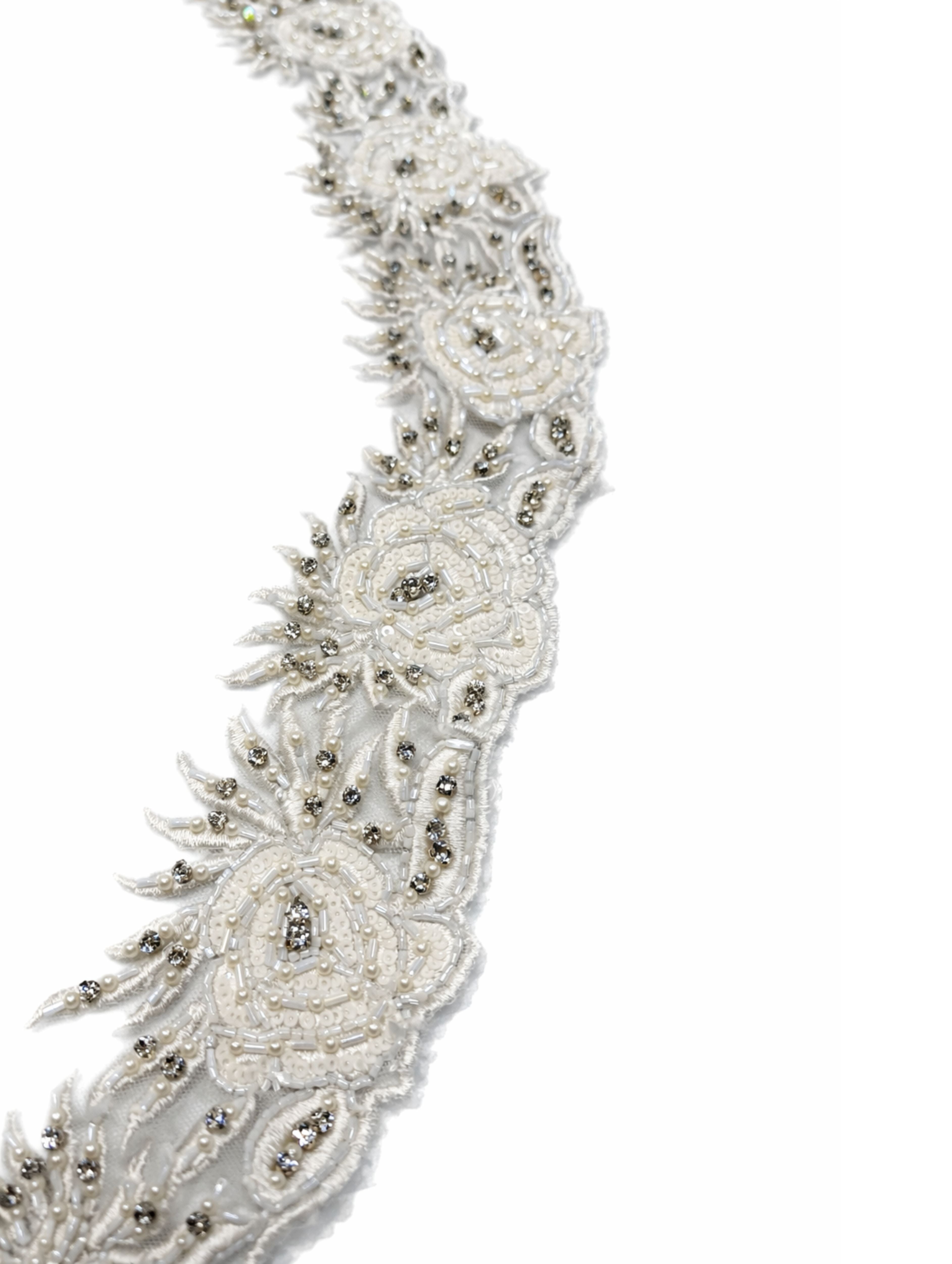 Detail van gebroken witte bloemen op bruidssluier met parels en steentjes op tule.