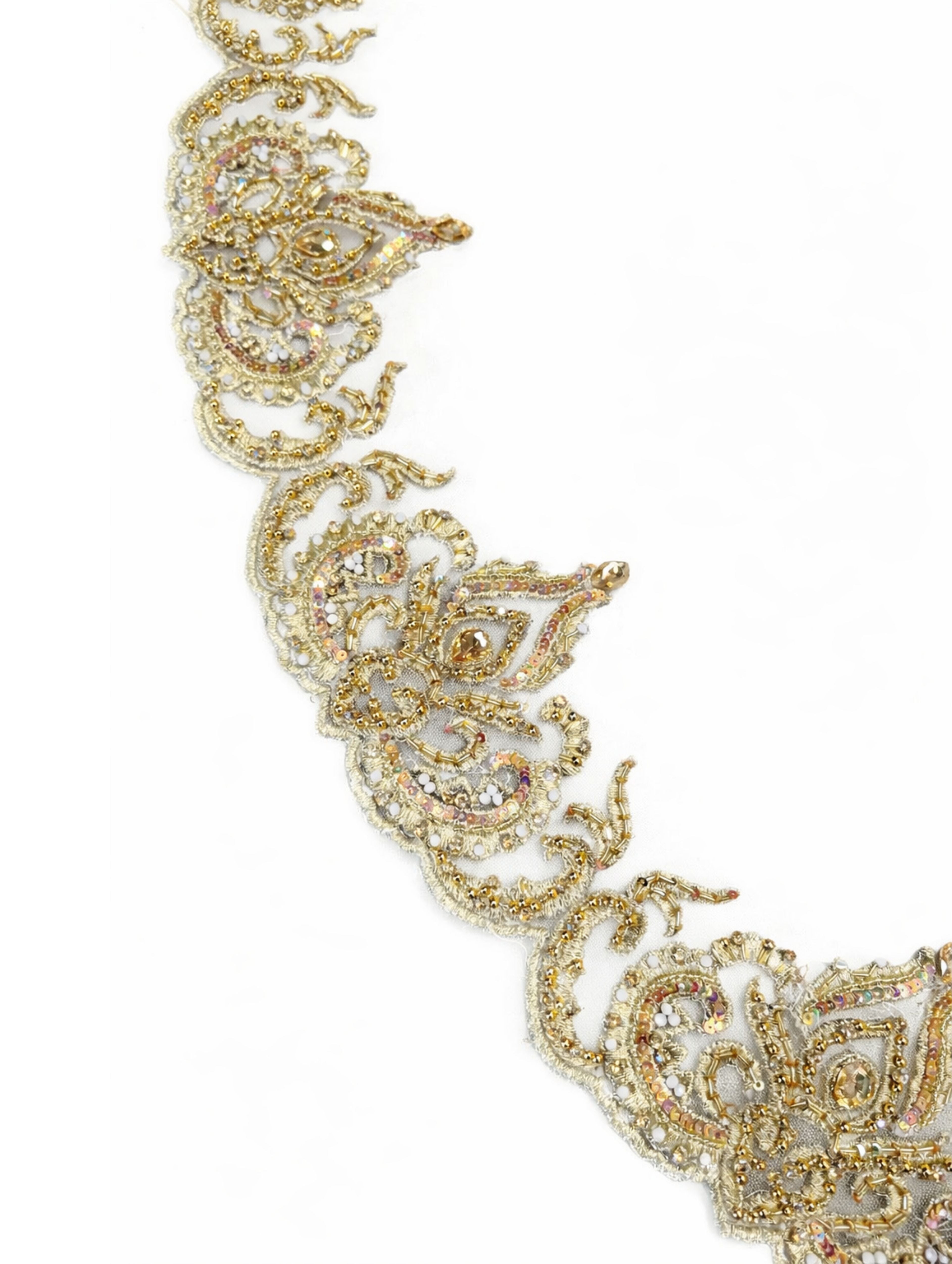 Detail van geborduurde rand van bruidssluier met gouden borduursel, parels en steentjes op crèmekleurige tule.