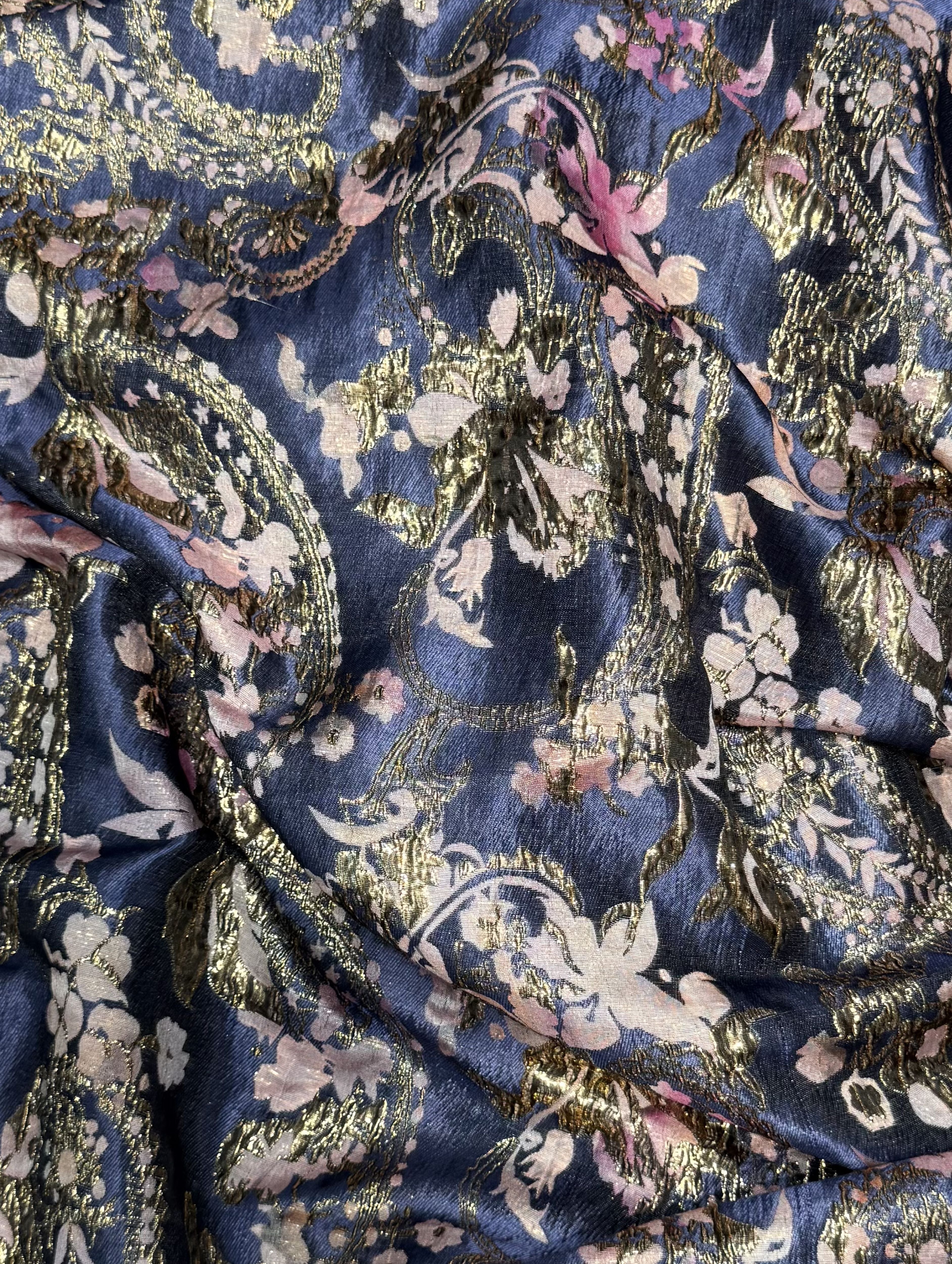 Luxe donkerblauwe brokaat stof met roze details.