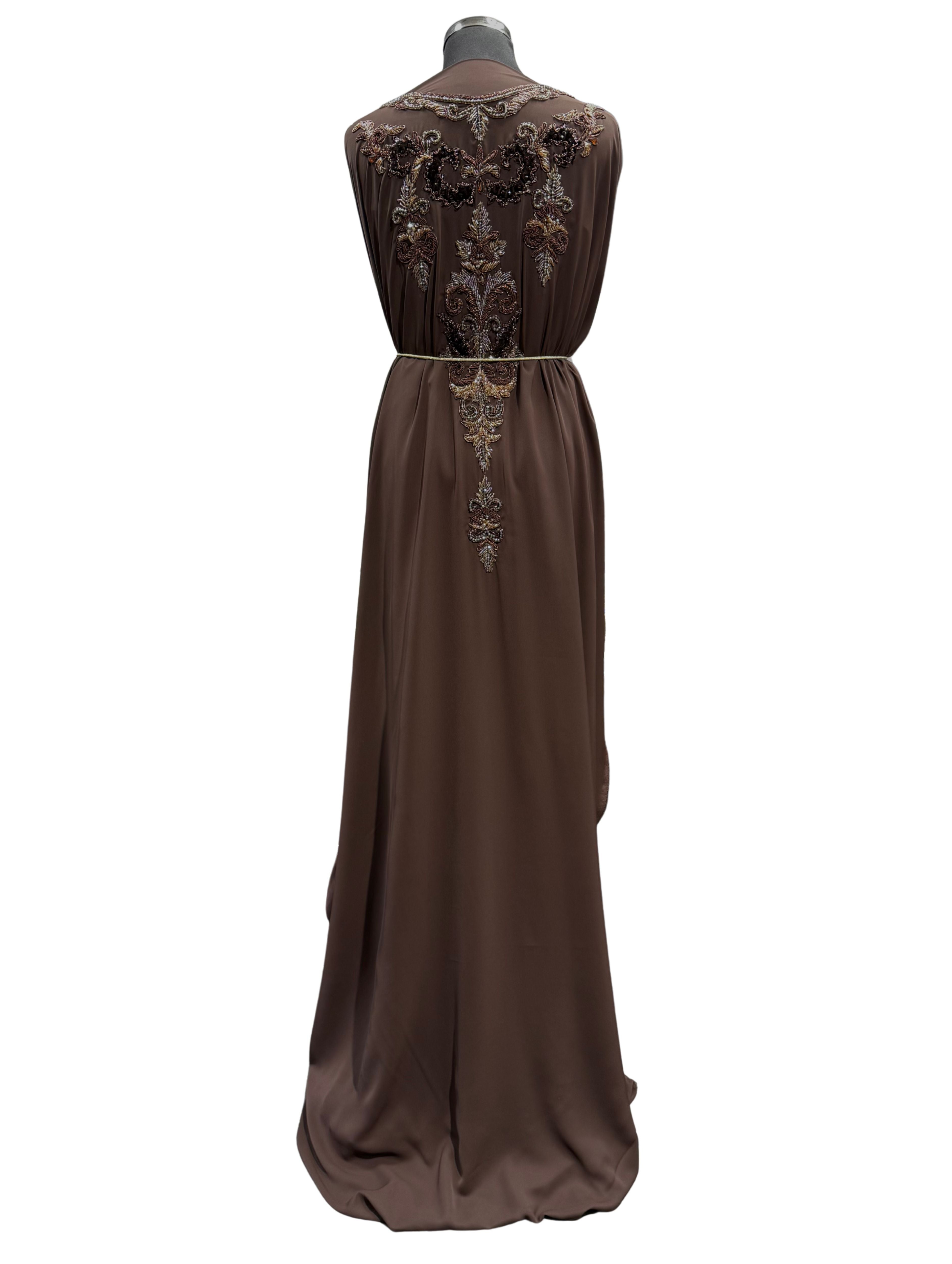 Achterkant van donkerbruine soepel vallende crêpe stof met tone-sur-tone kralen, stenen en velours patches.