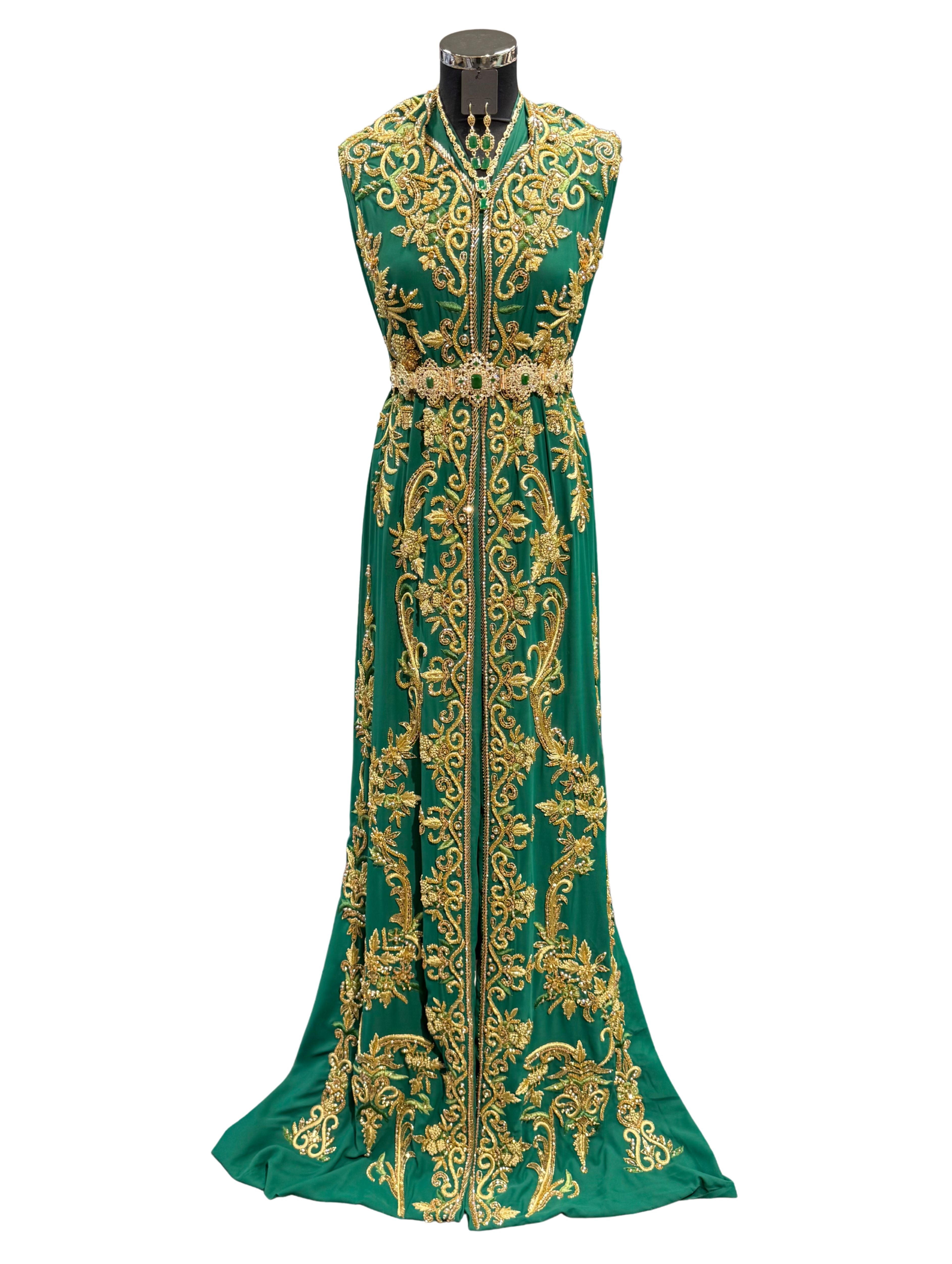 Voorkant van donkergroene soepel vallende crêpe stof, bewerkt met gouden details, borduurwerk in groentinten en kraaltjes.