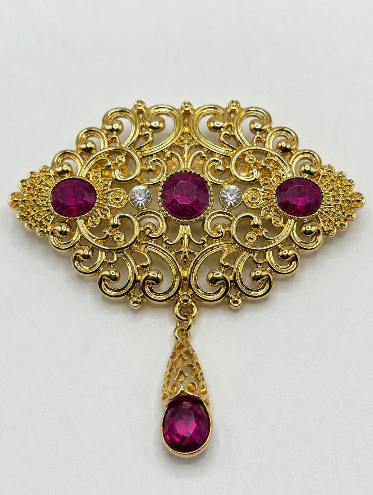 Gouden broche met fuchsia stenen in Marokkaanse stijl, een elegante accessoire voor een Marokkaanse kaftan of takshita.