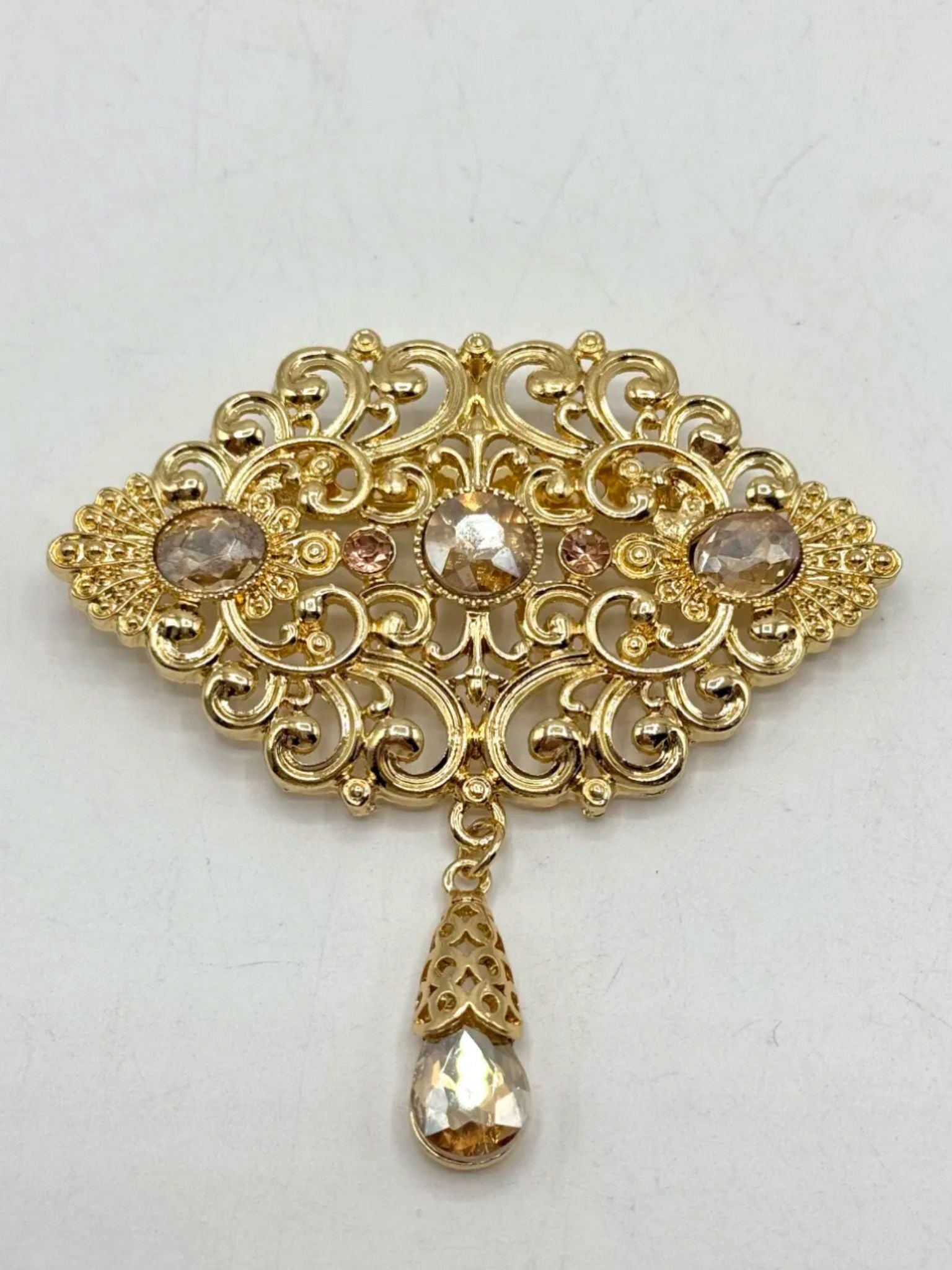 Elegante gouden broche met gouden stenen, perfect als accessoire bij takshita of feestelijke kleding.