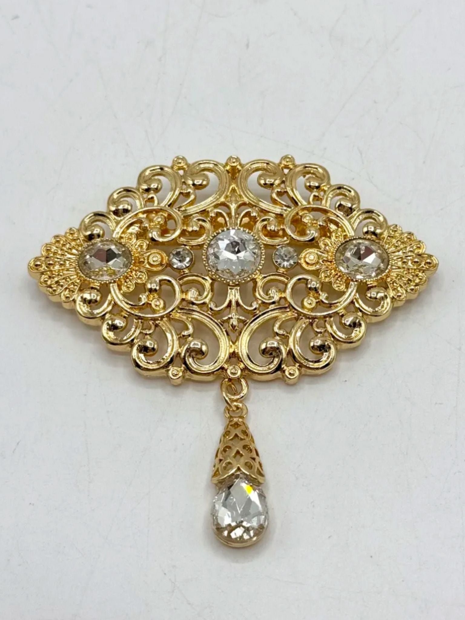 Elegante gouden broche met heldere stenen, perfect als accessoire bij takshita of feestelijke kleding.