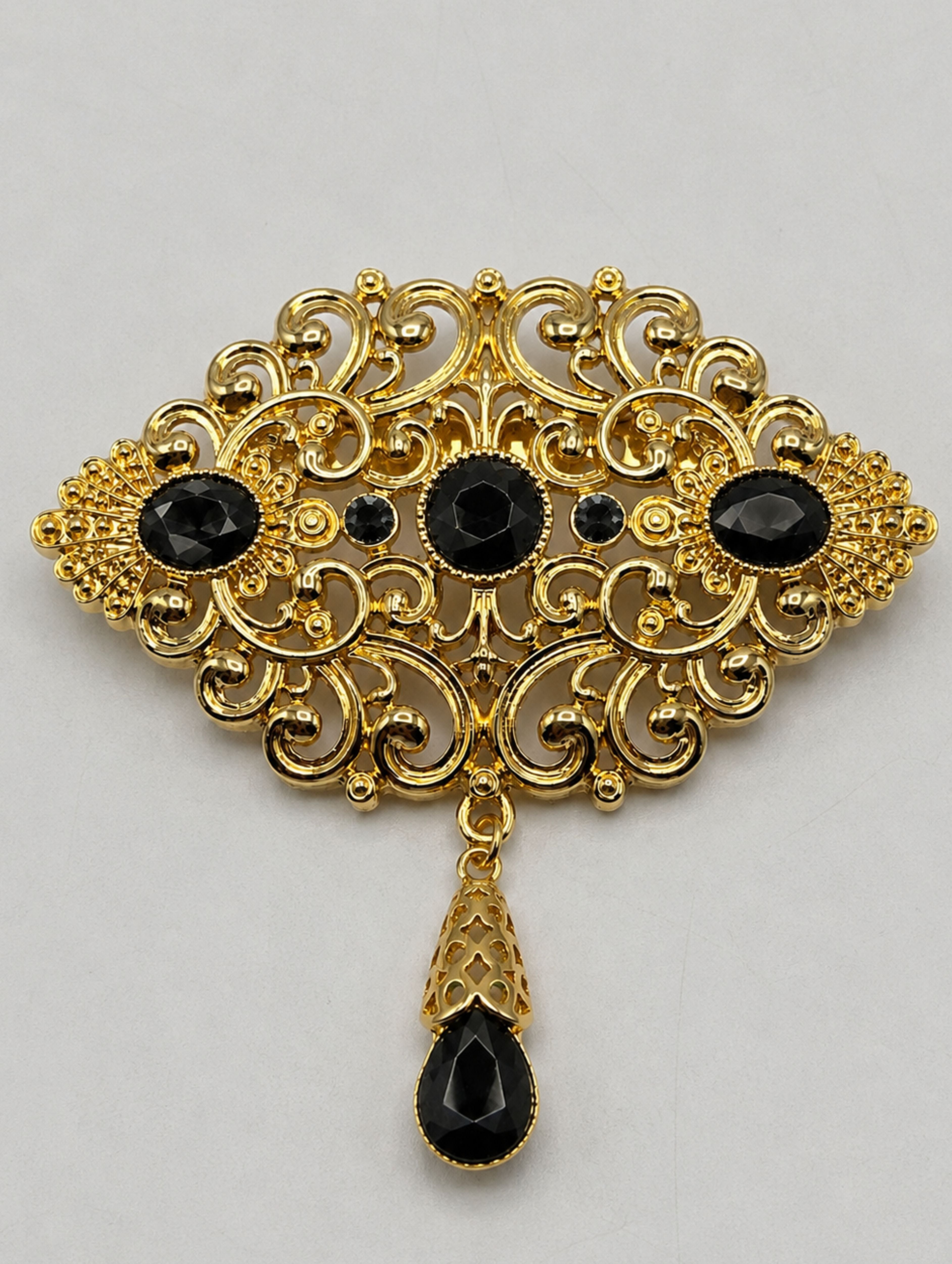 Gouden broche met zwarte stenen in Marokkaanse stijl, een elegante accessoire voor een Marokkaanse kaftan of takshita.
