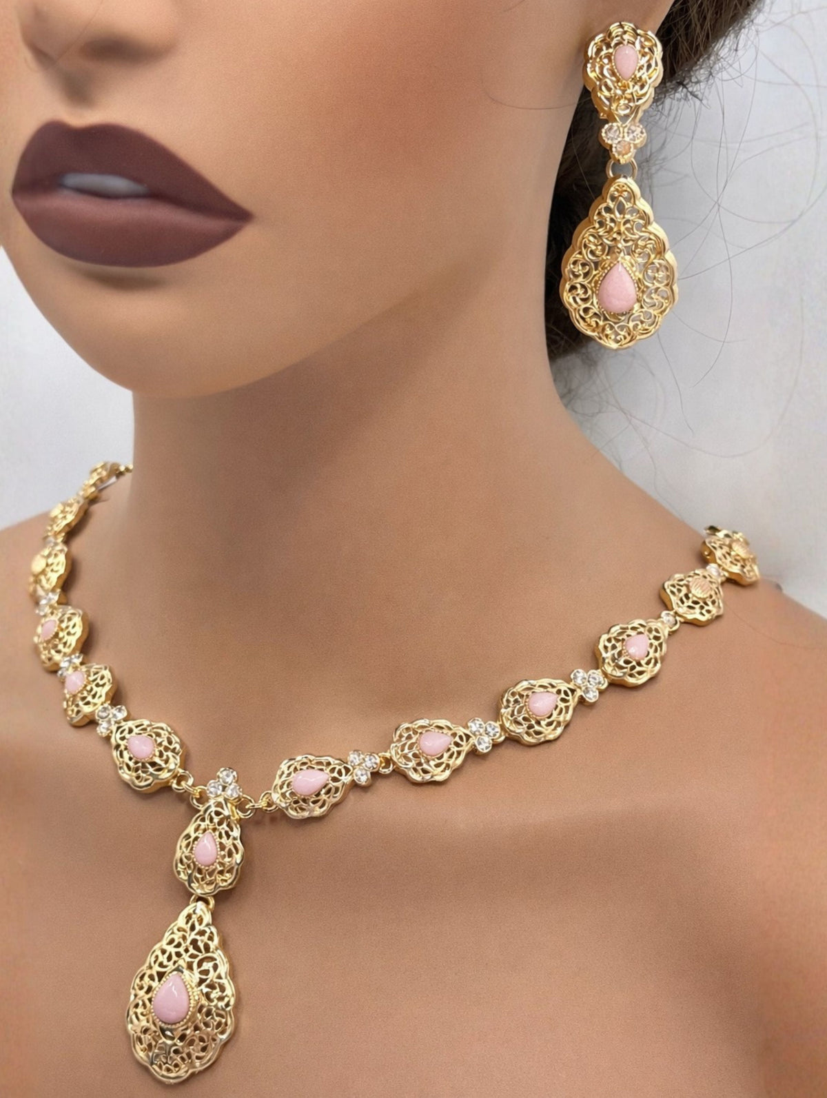 Gouden Marokkaanse sieradenset met lichtroze stenen, bestaande uit een in lengte verstelbare ketting en bijpassende oorbellen.