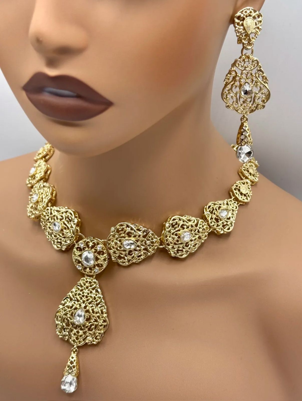 Elegante gouden ketting met oorbellen met heldere stenen, ideaal bij een takshita of feestelijke outfit.