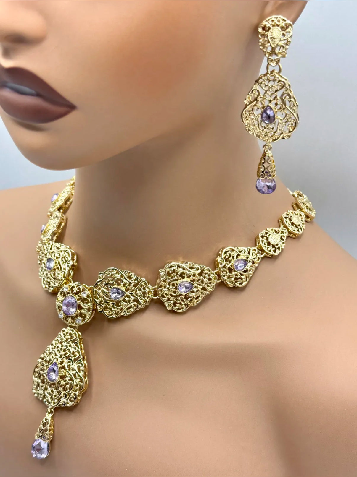 Elegante gouden ketting met oorbellen met lila stenen, ideaal bij een takshita of feestelijke outfit.