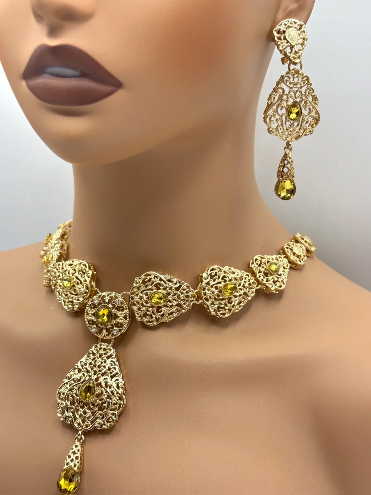 Elegante gouden ketting met oorbellen met olijfgroene stenen, ideaal bij een takshita of feestelijke outfit.