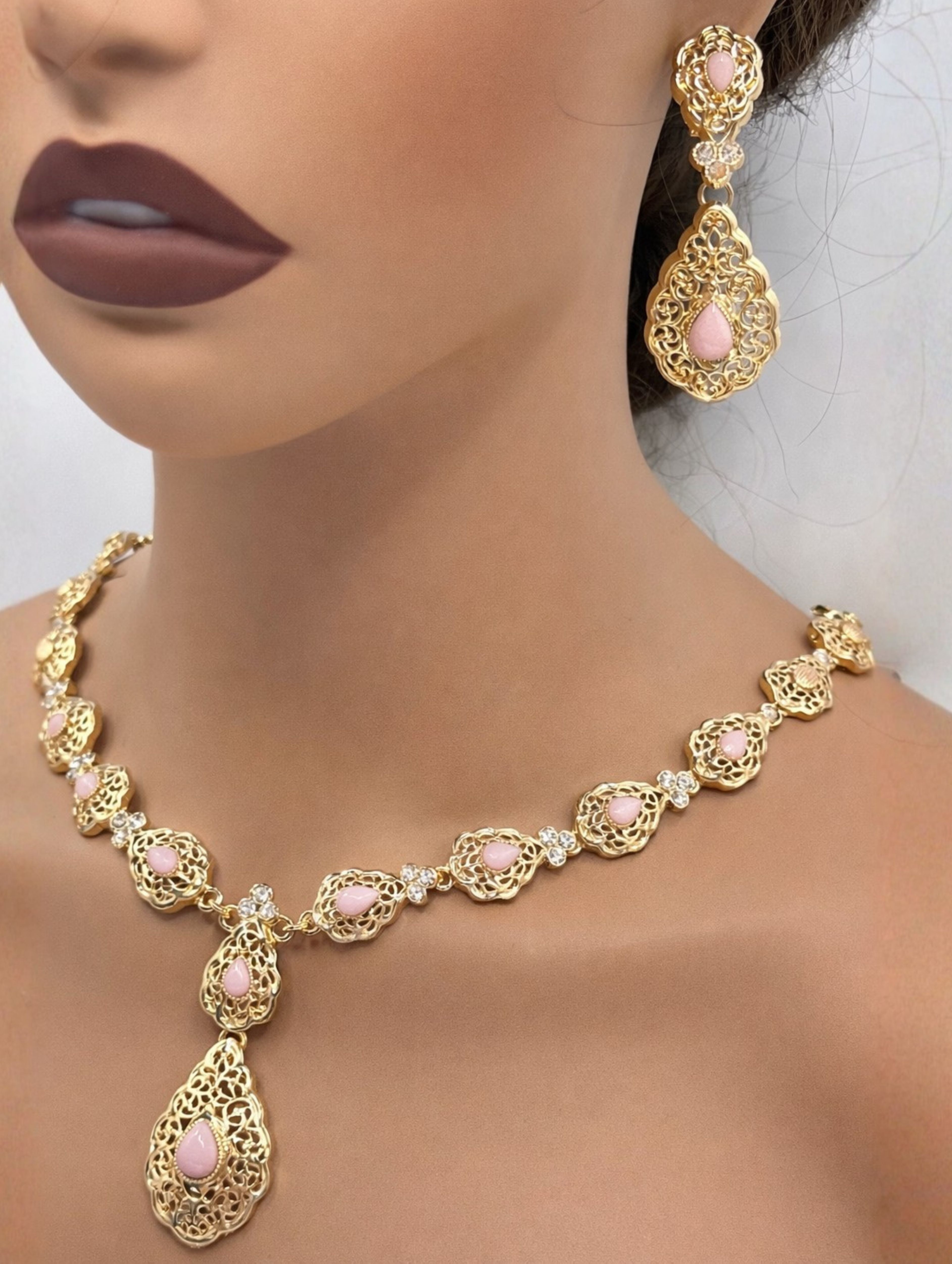 Elegante gouden ketting met oorbellen met poederroze stenen, ideaal bij een takshita of feestelijke outfit.