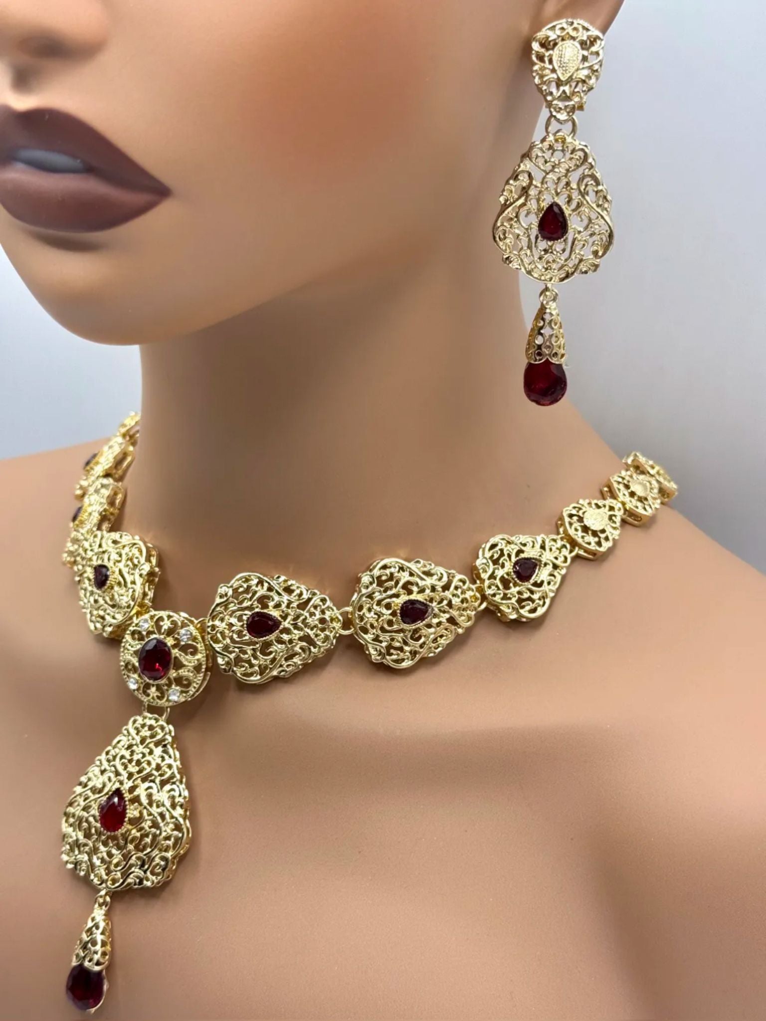 Gouden ketting met bijpassende oorbellen met rode stenen, voor takshita of feestkleding.